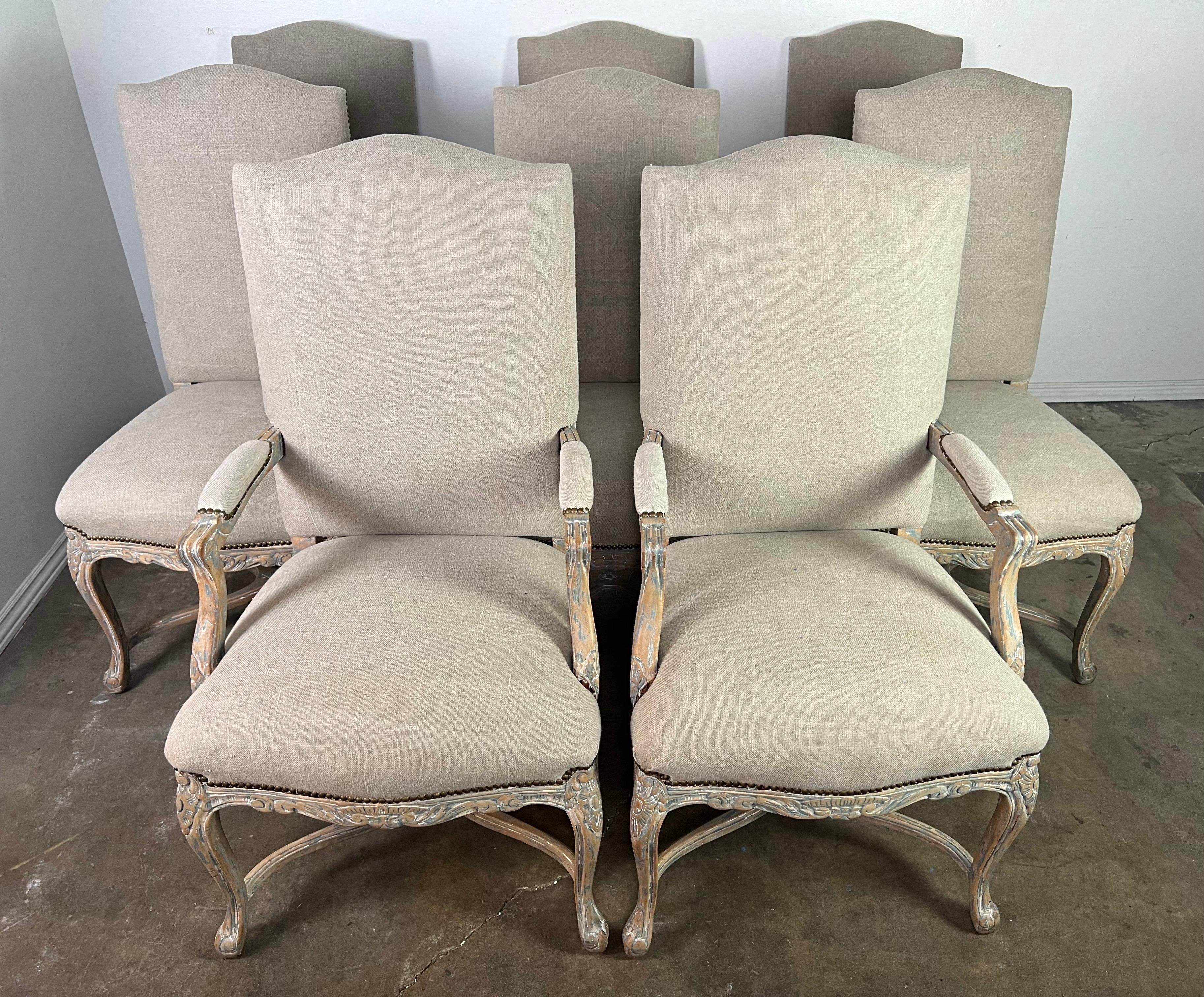 Set of eight Louis XV style French dining chairs, each exuding the elegance and graceful curves characteristic of the era.  These chairs are upholstered in Belgium linen, a material revered for its durability and classic beauty.  The natural texture