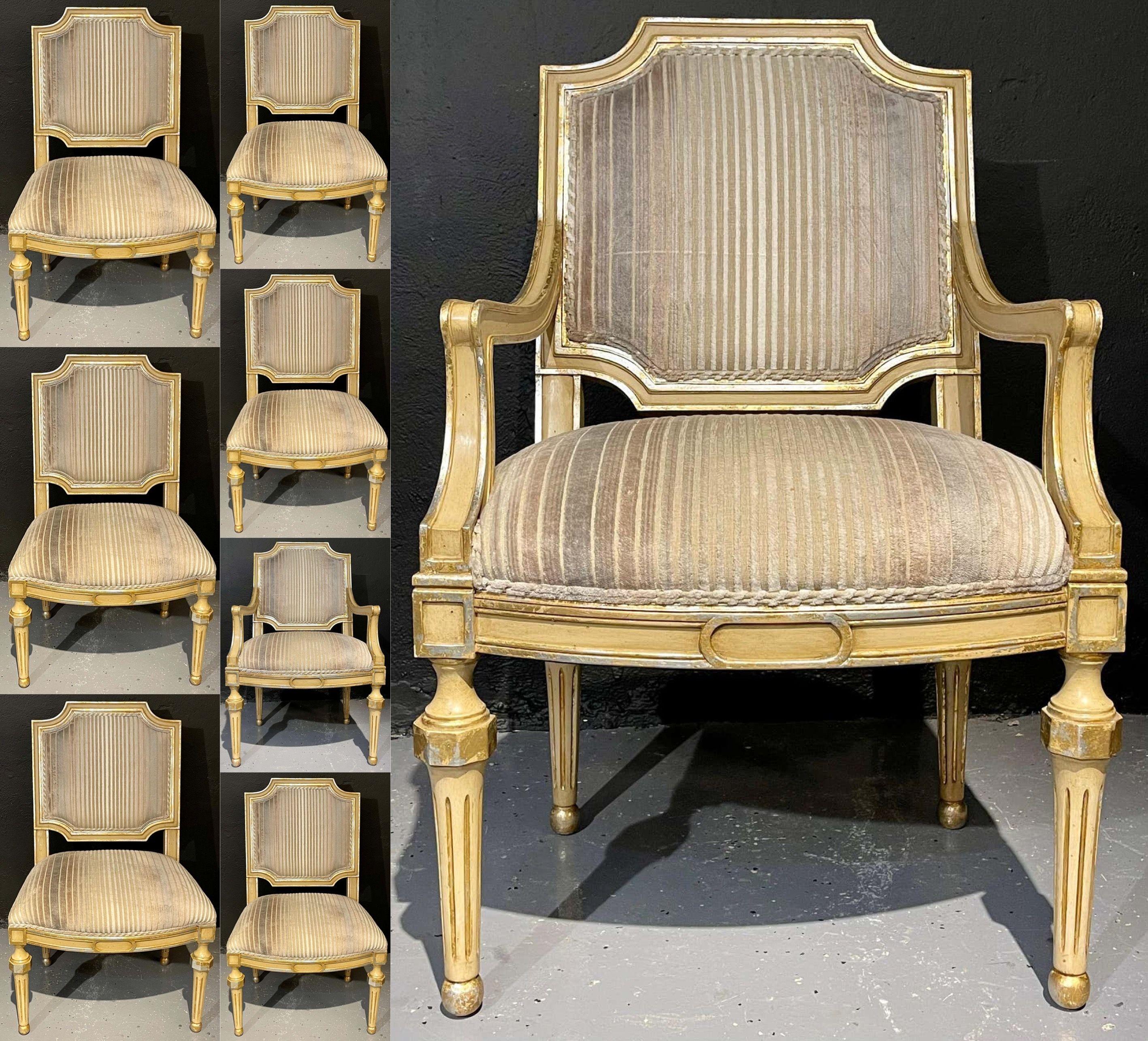 Set of eight Louis XVI style dining chairs. Painted and parcel-gilt decorated. These fine Hollywood Regency Maison Jansen style dining chairs are wonderfully crafted in an off-white and parcel-gilt decorated worn frames with custom upholstery. The