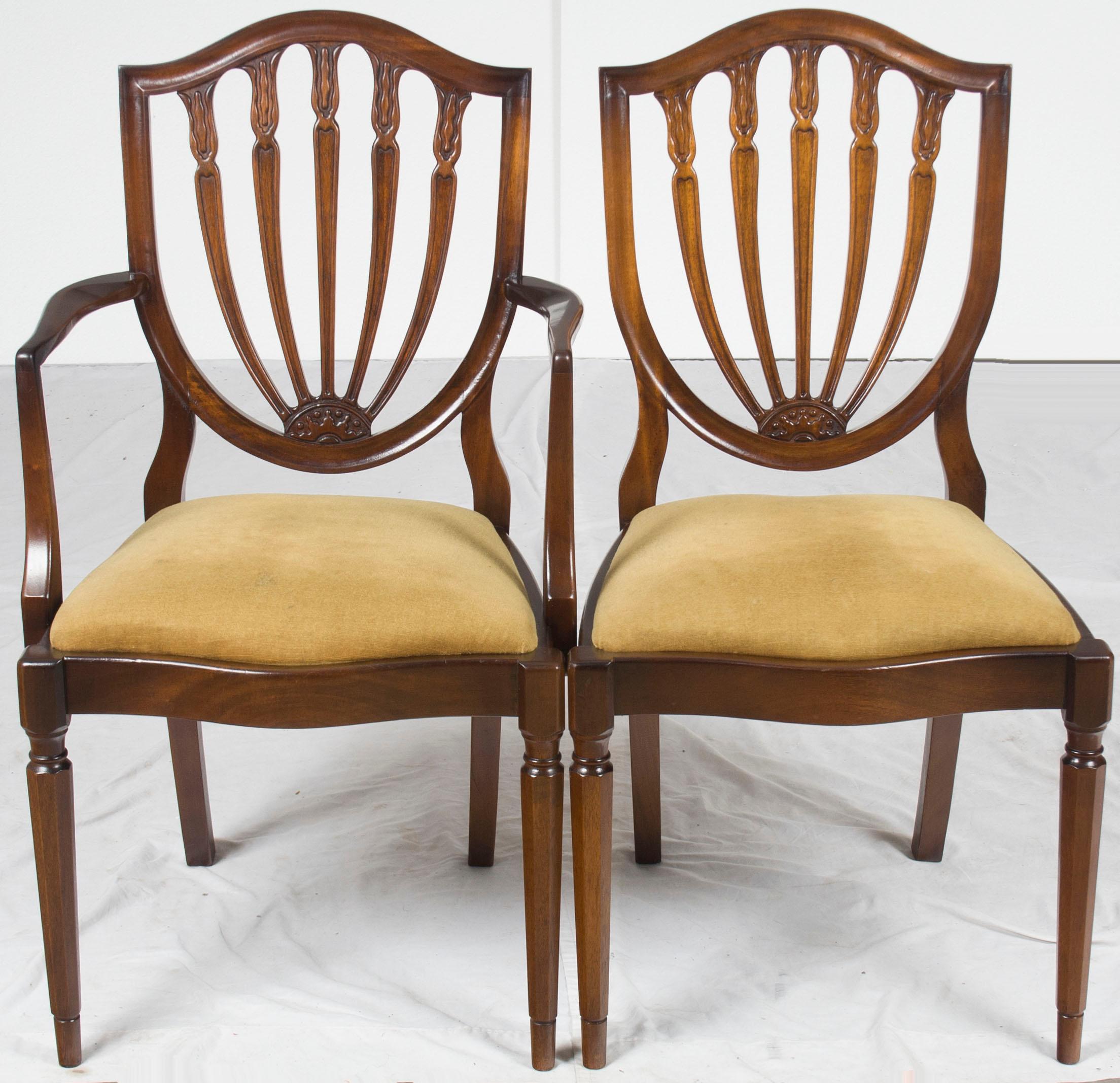 These gorgeous mahogany Hepplewhite style shield back dining chairs have a beautiful dark mahogany color. The set of dining chairs consists of two arm chairs and six side chairs. Originally made in England around 1960, these chairs are marvelous to