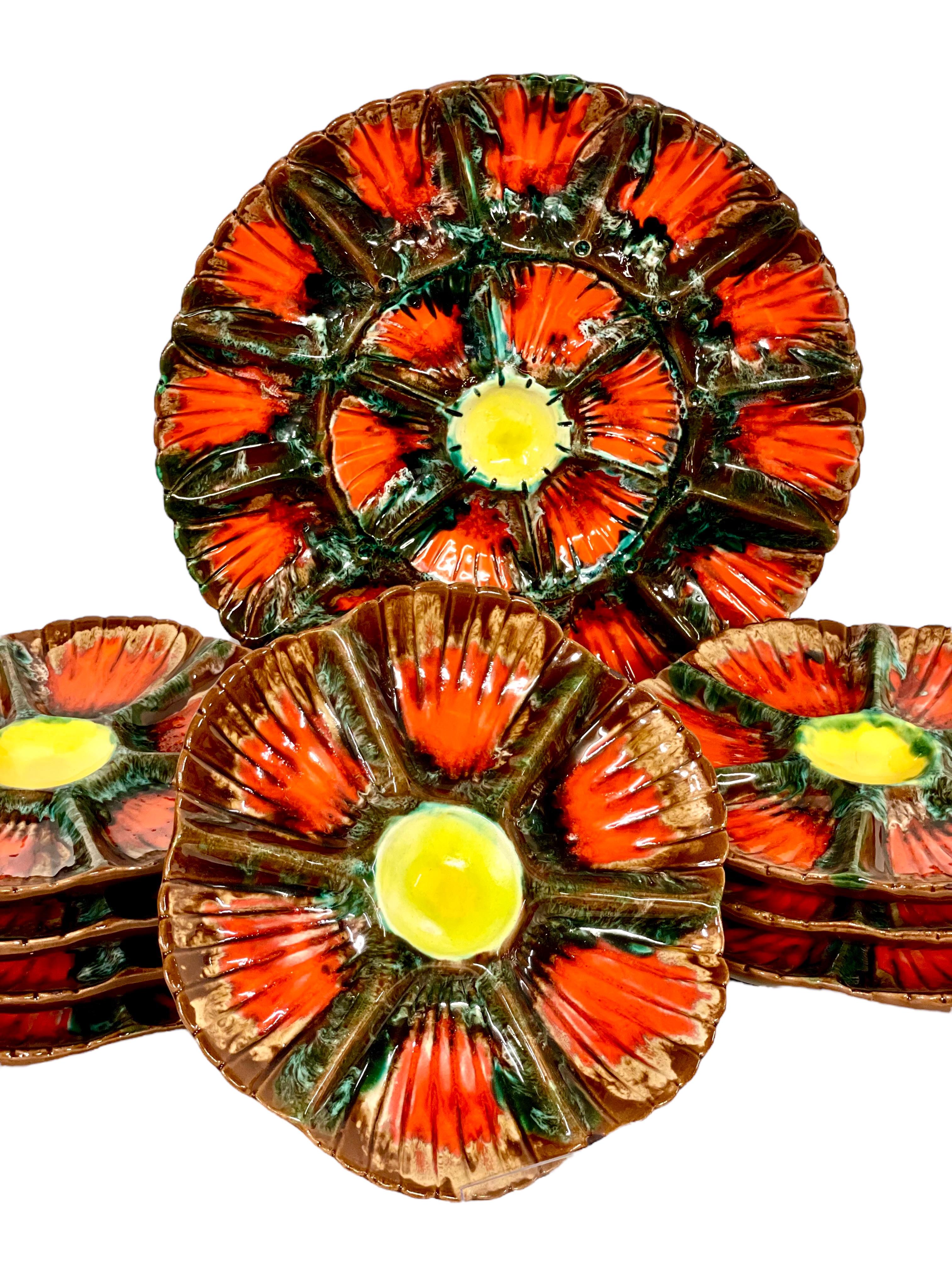 A very eye-catching set of eight Vallauris-style ceramic oyster plates and a serving dish decorated in vibrant polychrome enamel in wonderful shades of chocolate, crimson and yellow. Each of the smaller dishes is divided into sections, and is
