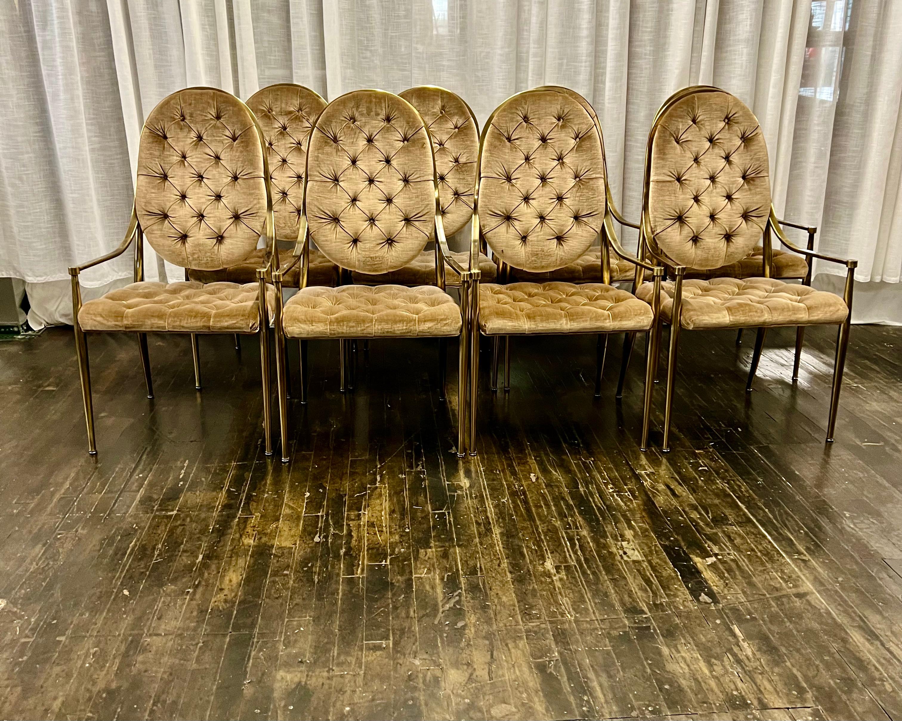 A stunning set of eight mid-century brass Mastercraft dining chairs.  These chairs feature antiqued brass frames with arms and gorgeous tufted velvet upholstery. The chairs have their original upholstery which seems to be a shade of bronze (perhaps