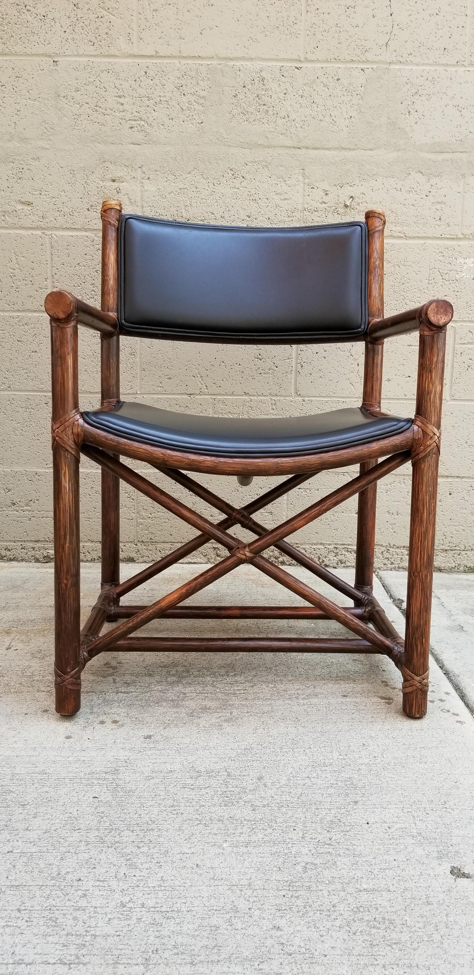 A set of eight bamboo or rattan armchairs with black leather seats and backrest. Quality craftsmanship throughout with all leather bindings intact. Arm height 25.5
