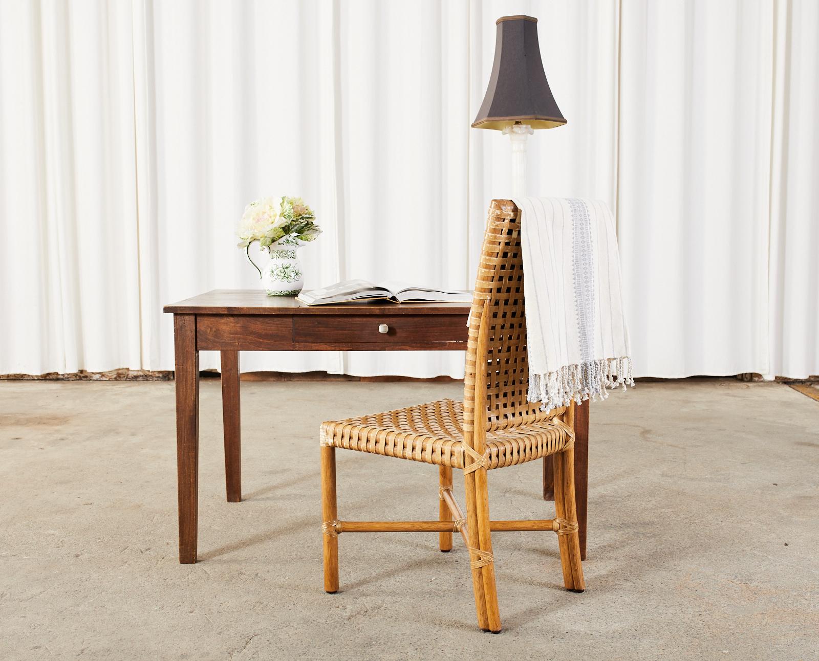 Weathered set of eight McGuire rawhide dining chairs. Model #MCLM71 featuring geometric lattice leather laces. Made in the California organic modern style by McGuire. Crafted from thick rattan poles lashed together on the exposed joints with rawhide