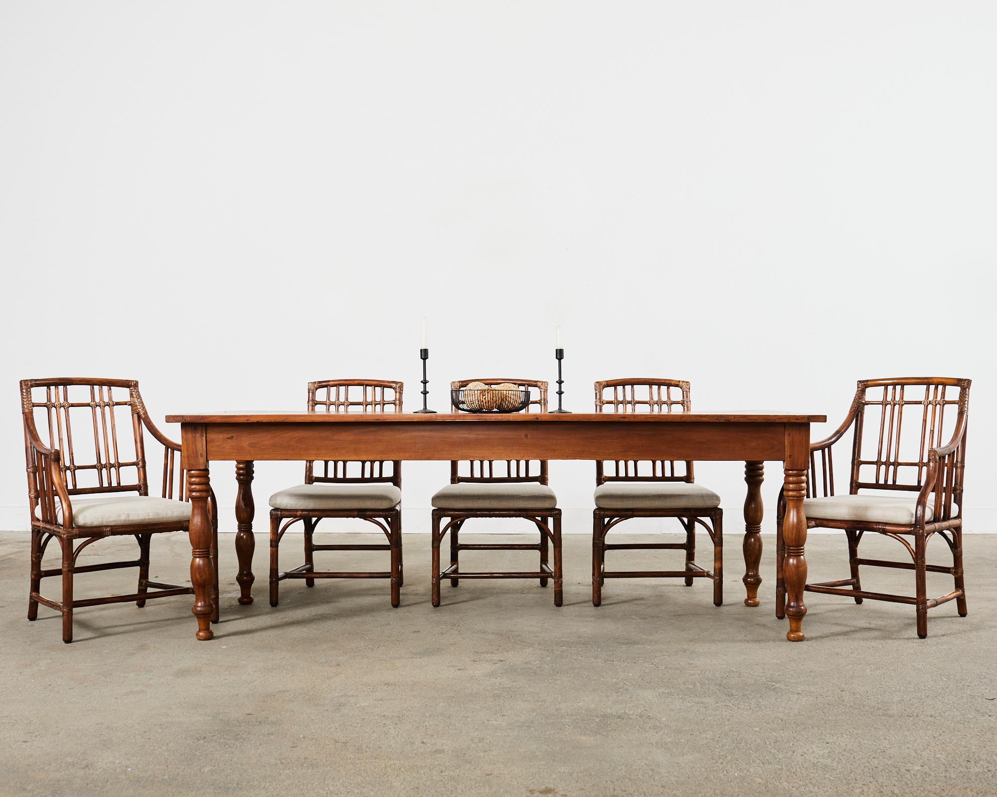 Architectural set of eight rattan dining chairs made in the organic modern style by McGuire. The set consists of six side chairs and two armchairs measuring 22 inches wide. Known as the Balboa chair designed by Elinor McGuire model #MCJSC 151, and