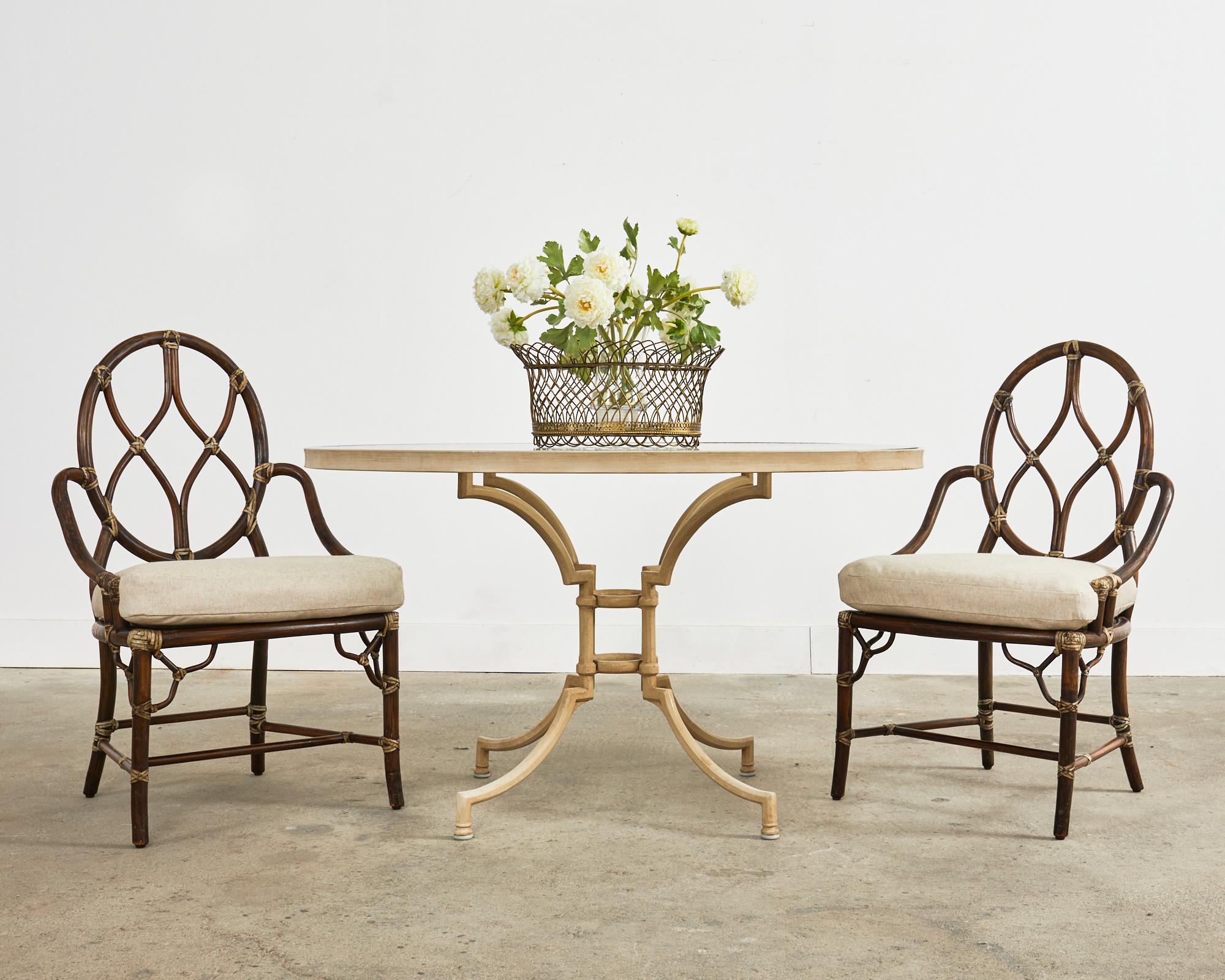 Rare set of eight rattan and cane dining chairs featuring a cameo back with graceful x form designs. Made in the California coastal organic modern style by McGuire San Francisco, CA. The frames have an intentionally aged, distressed patina on the