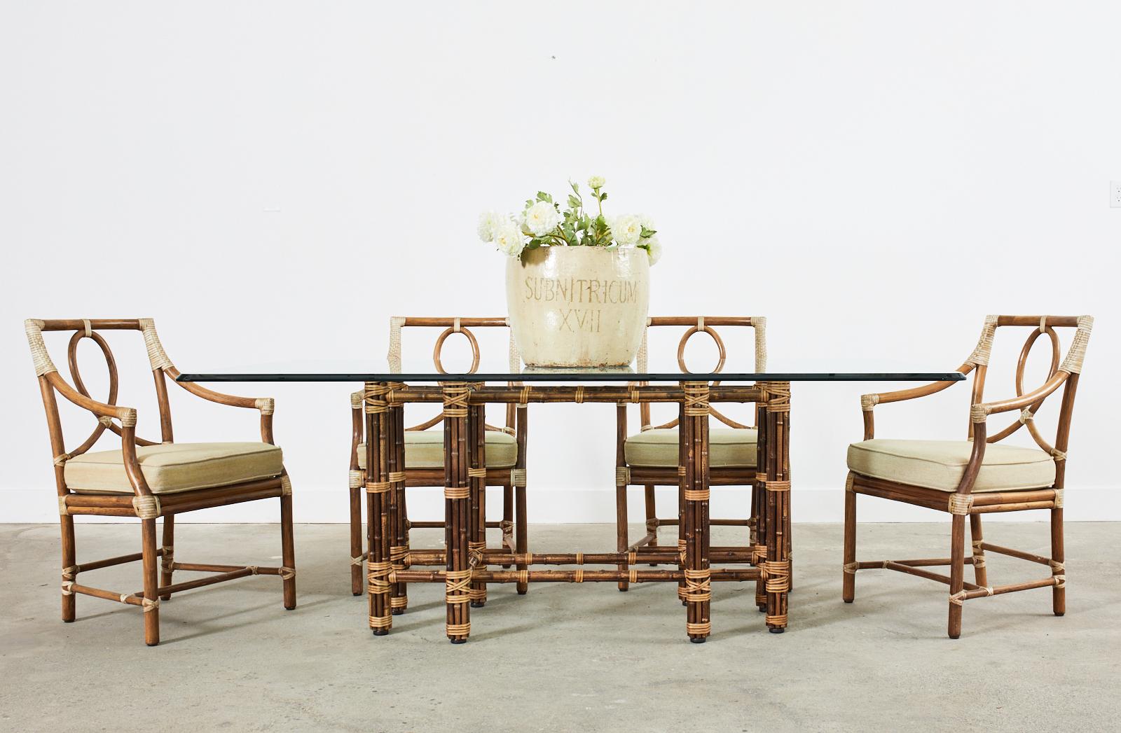 Graceful and elegant set of eight genuine McGuire rattan loop back dining chairs made in the California coastal organic modern style. Known as Leona loop back chairs ( model # MCGJSC58) these chairs were designed by Elinor McGuire in the 1970's. The