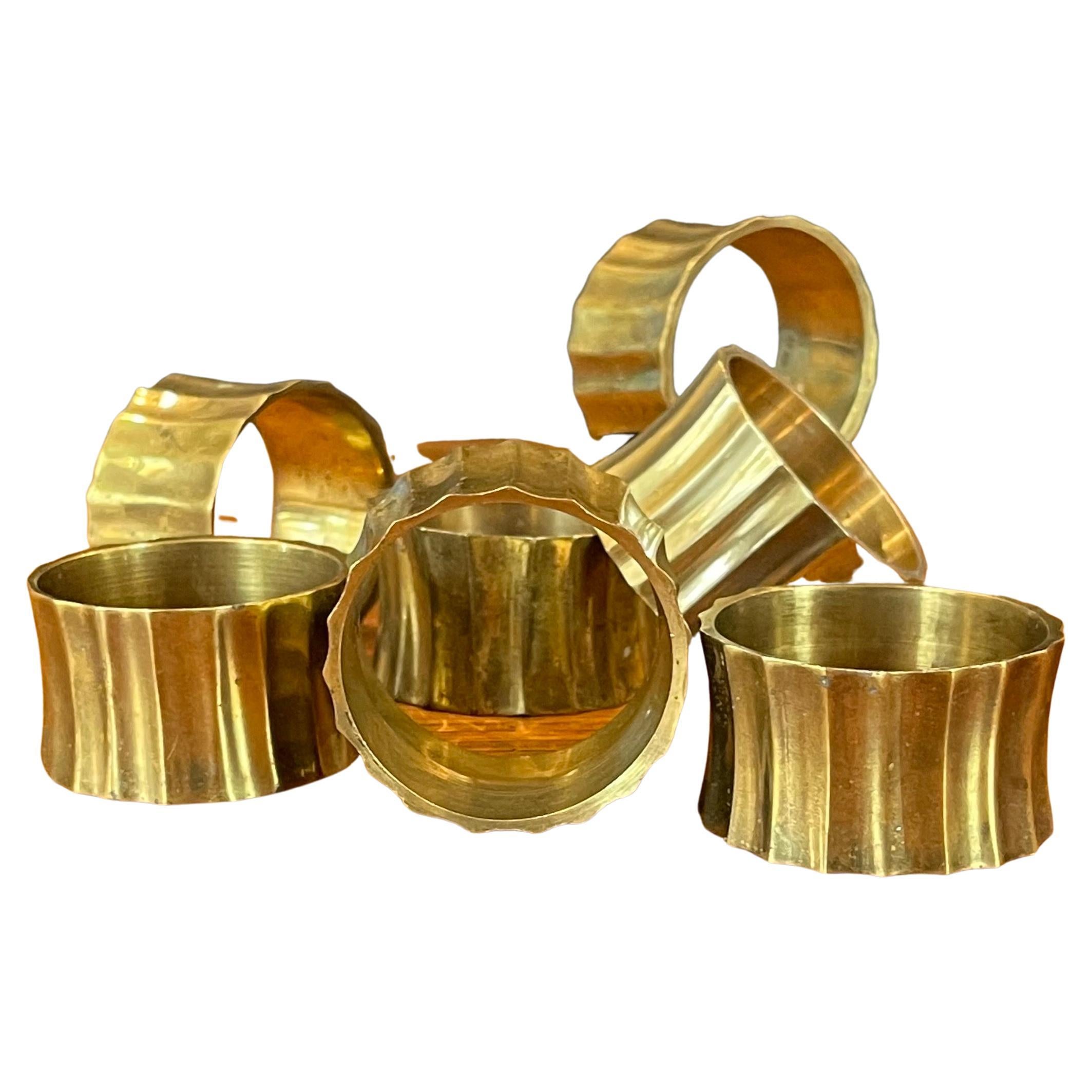 Set of eight MCM brass napkin rings, circa 1970s. The rings have a circular design and measure 1.875