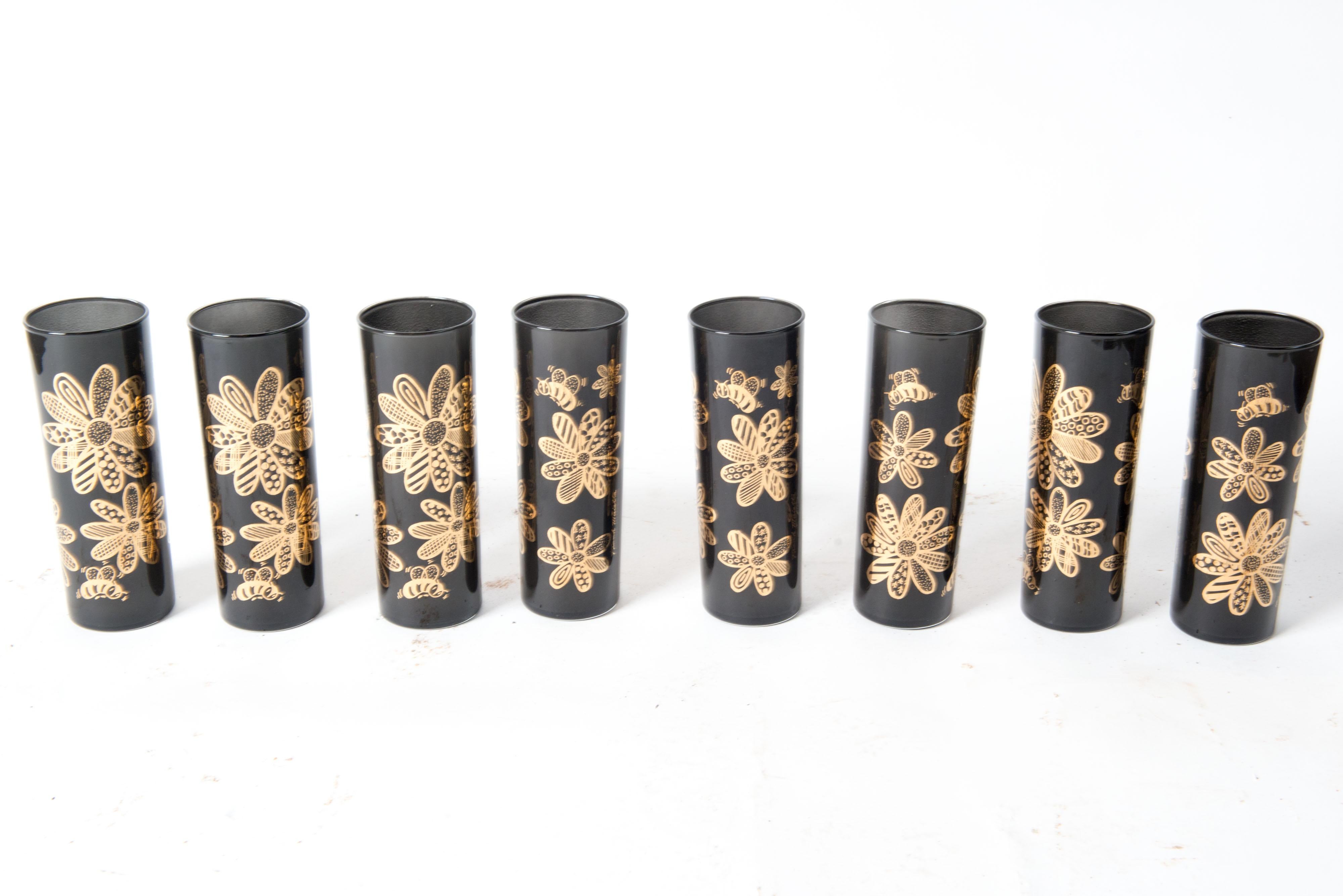 Mid-century modern stylish set of eight tall drinks glasses. Black glass decorated with whimsical gold flowers. Add some pizazz to your bar.