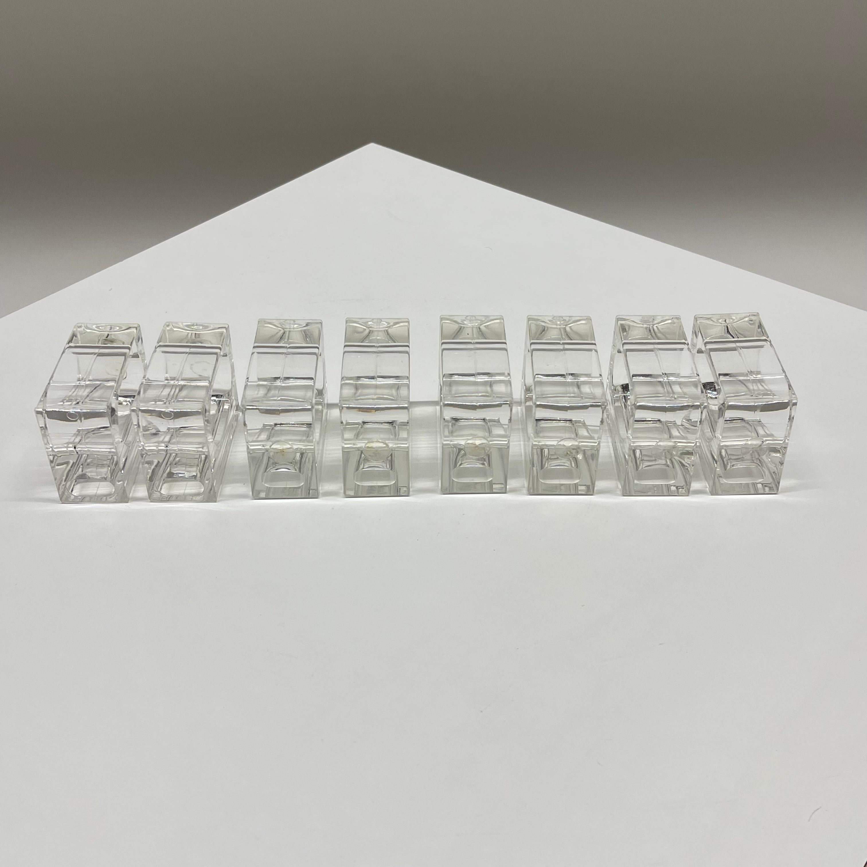 Stunning set of eight Mid-Century Modern napkin rings or napkin holders with a geometric design. Rendered in polished transparent clear lucite. The design is rectangular in shape on the exterior with an oblong cut out for the napkin on the interior.