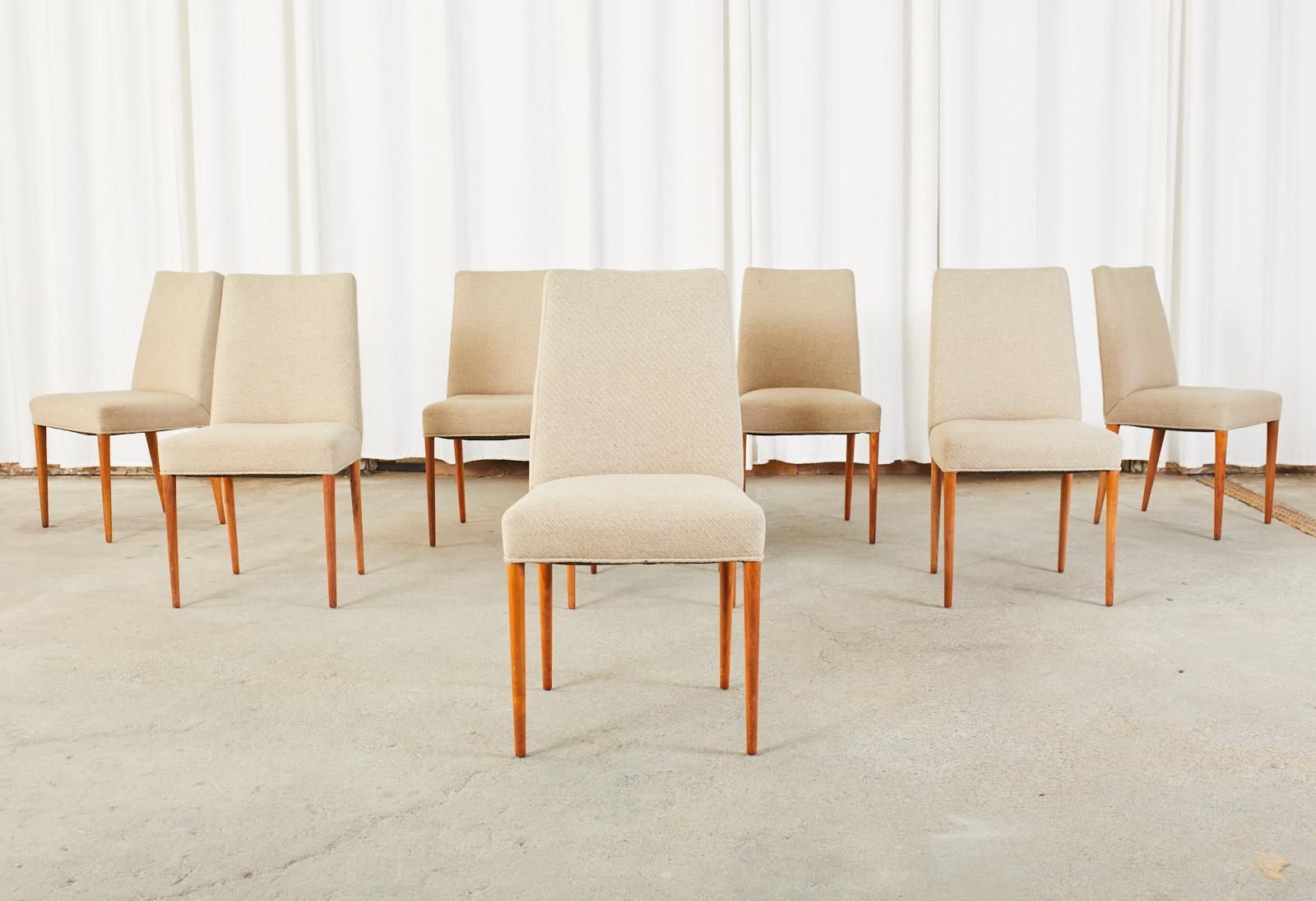 Sleek set of eight Scandinavian modern style dining chairs featuring a hardwood frame. The chairs have a lovely profile with a wool fabric upholstery. Supported by rounded, tapered legs with excellent joinery and craftsmanship. From an estate in San