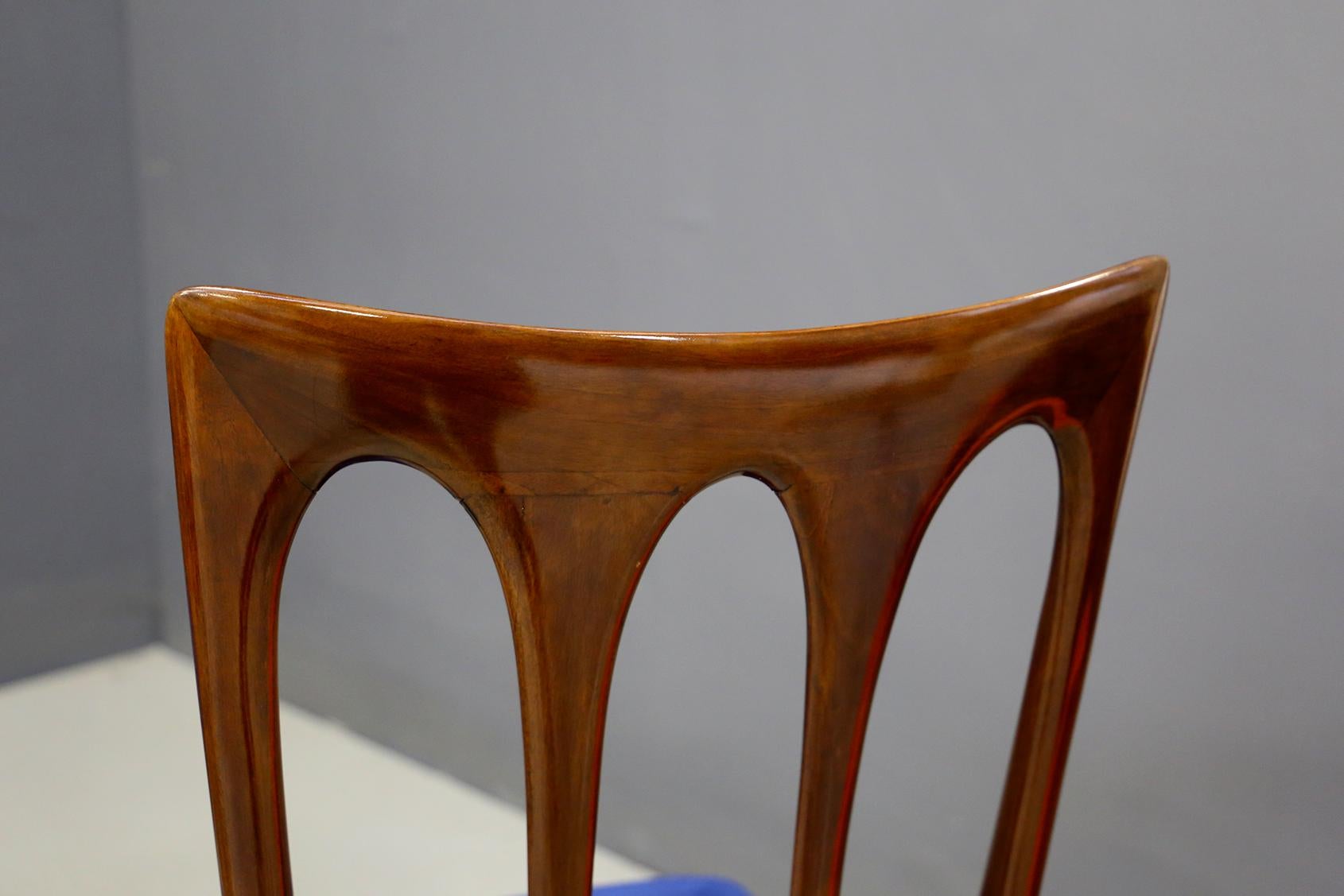 Elegant and refined set of eight chairs by Guglielmo Ulrich from 1950. The set has been finely restored. The structure is made of walnut wood. The seat is covered in blue velvet. The peculiarity of the set is its backrest with three oval inserts.