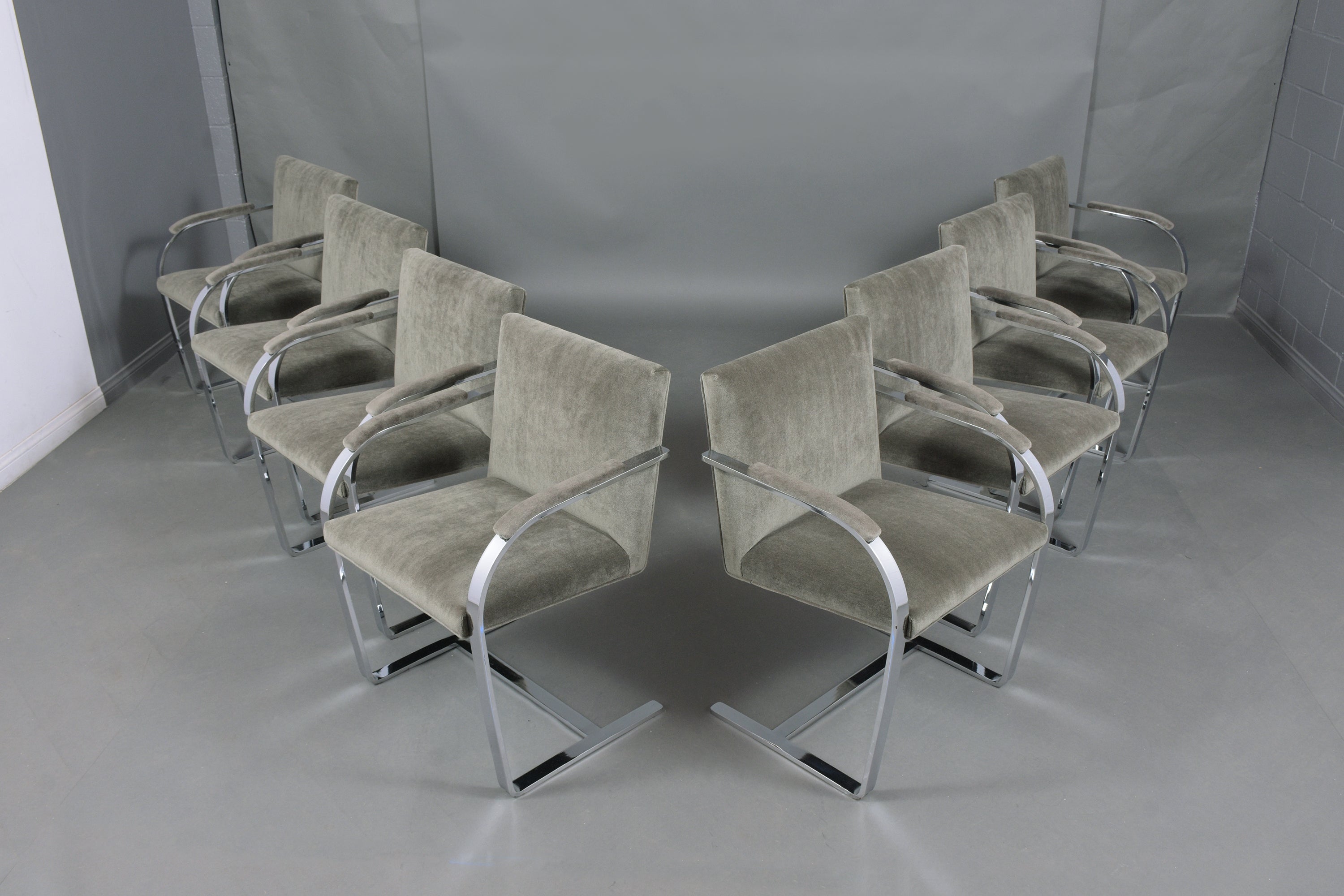 This set of eight dining chairs after Mies Van Der Rohe flat bar Brno chairs by Knoll is in good condition and has been newly upholstered by our team of expert craftsmen. The chairs have a sturdy steel frame that has been polished/buffed and is