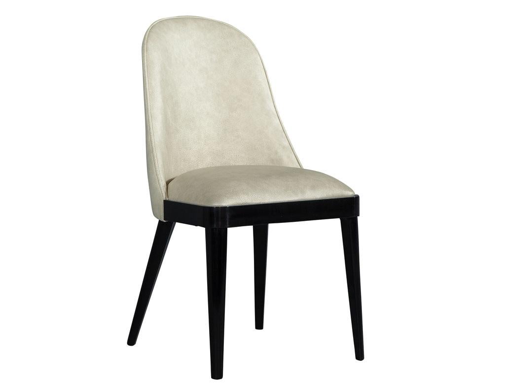 Carrocel custom modern dining chairs with elegantly sculpted curved backs and hand polished black lacquer legs and trim. These chairs are upholstered in a designer Italian butter soft cream leather. The frames are made in Italy, with finishing and