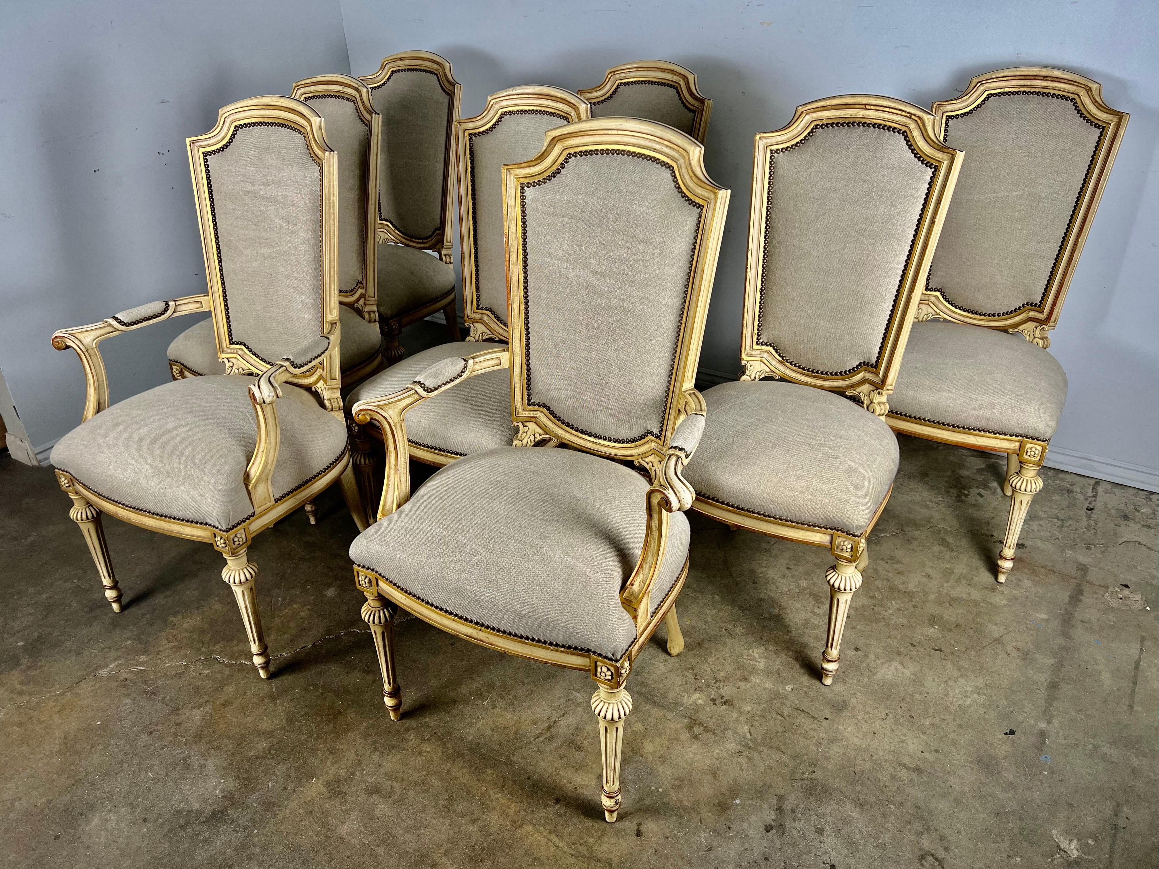 Set of eight 1930's painted Neoclassical style dining chairs. The chairs stand on four straight legs that have a fluted ball at the top of the legs. The chairs are beautifully painted in a two-tone coloration. They are newly upholstered in a Belgium