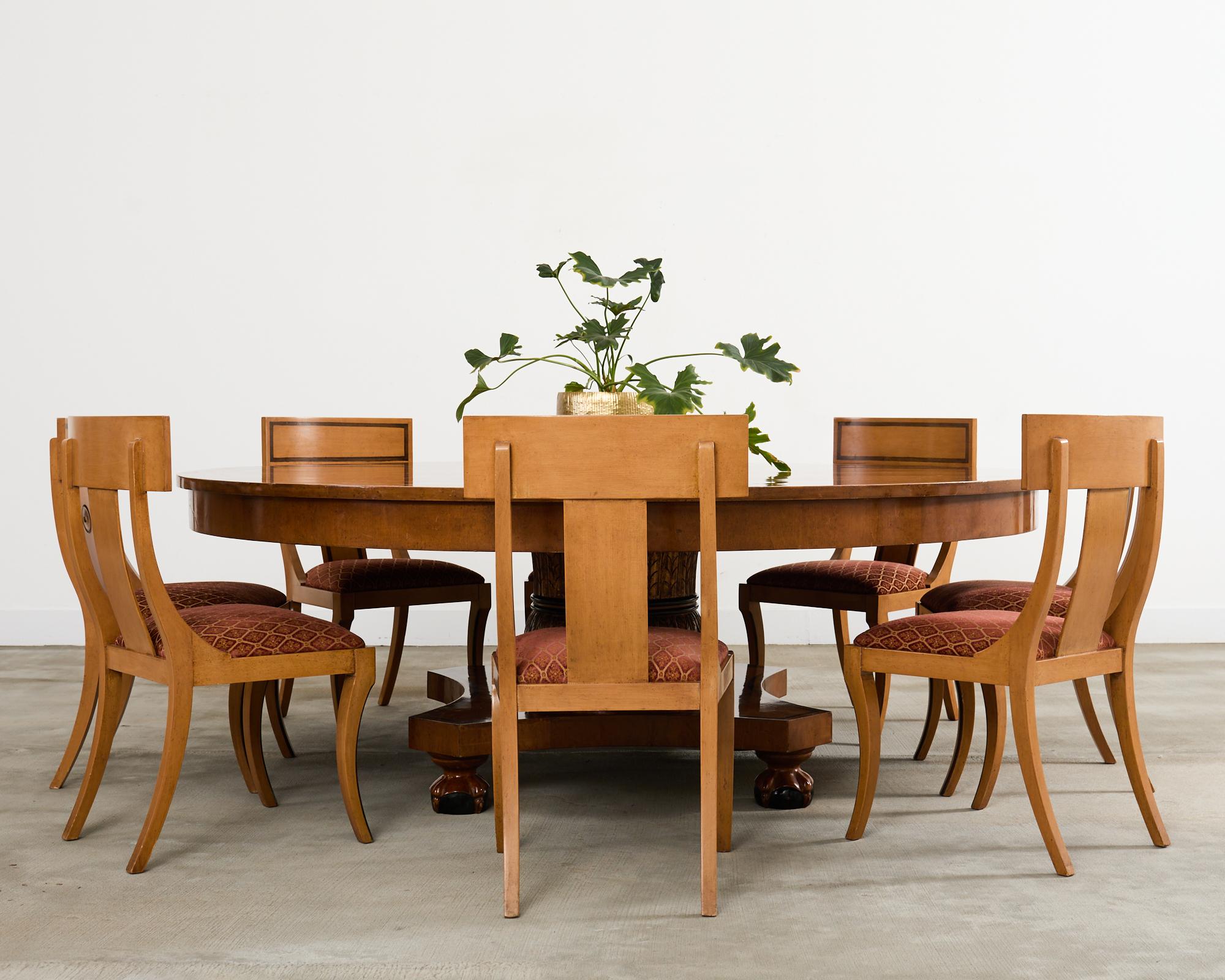 Dramatic set of eight klismos dining chairs constructed in the Greco-Roman neoclassical taste. The chairs feature a tablet back with a curved splat decorated with a disc. The seat has a thick, plush seat cushion with vintage upholstery that still