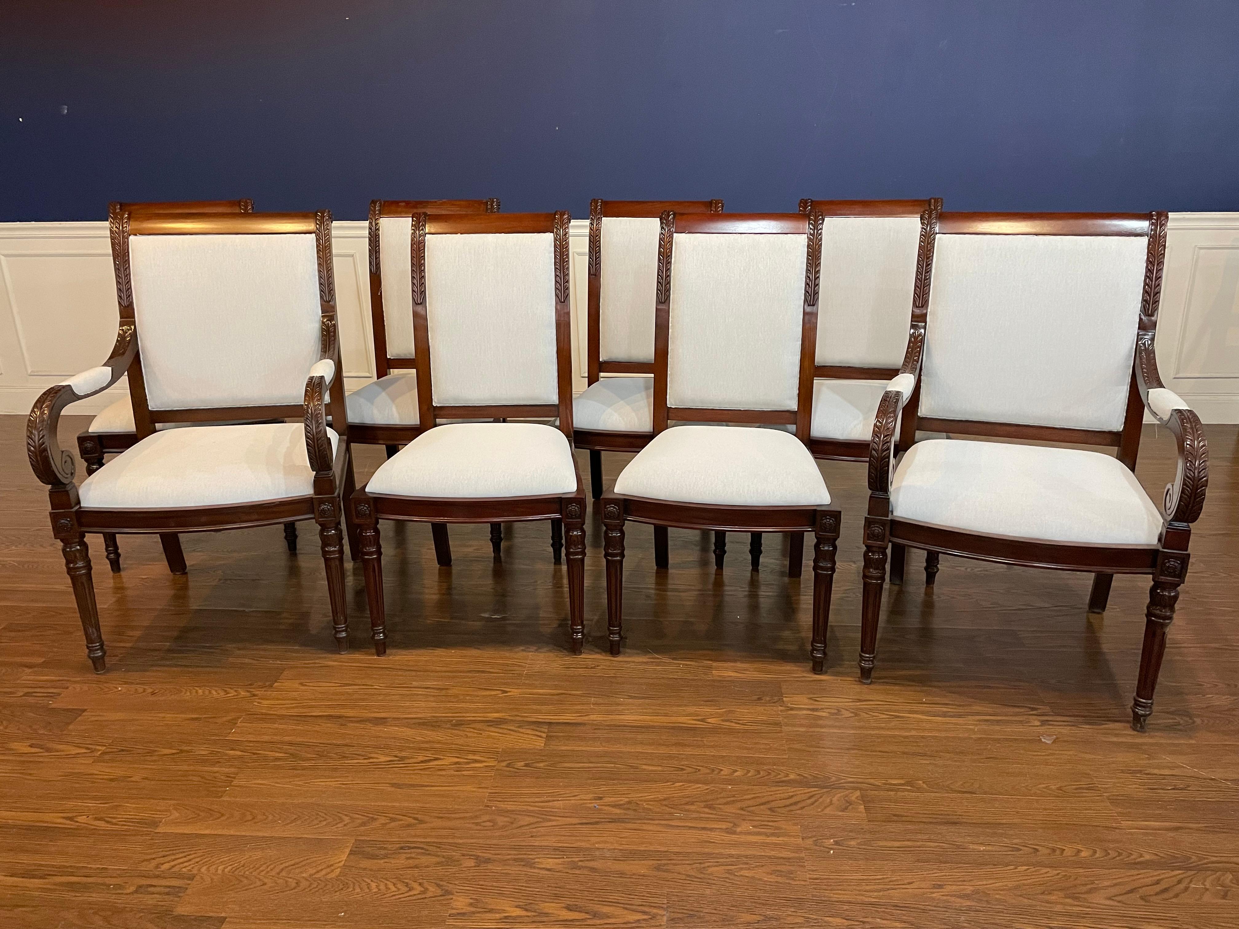 This is a set of eight ( 2 arms and 6 sides) Newport mahogany dining chairs by Leighton Hall. They feature acanthus leaf carvings on the backs and classic round fluted and tapered legs.  The chairs are finished in a medium brown mahogany color with