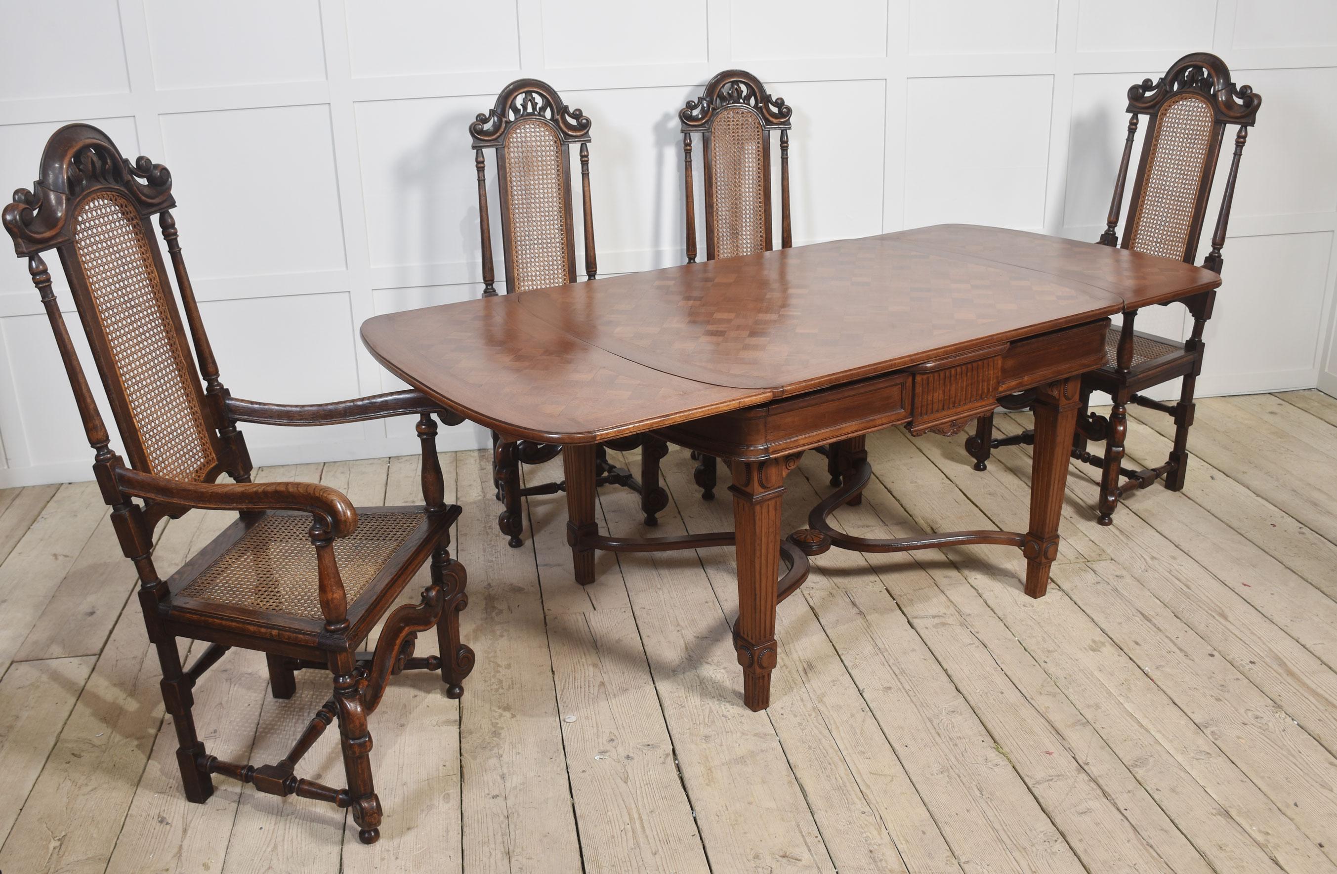 Conjunto de ocho sillas de comedor de roble de respaldo alto, compuesto por dos sillones y seis sillas, con barandillas de cresta arqueada, respaldo de caña y fiador, todo ello elevado sobre patas talladas en volutas unidas por