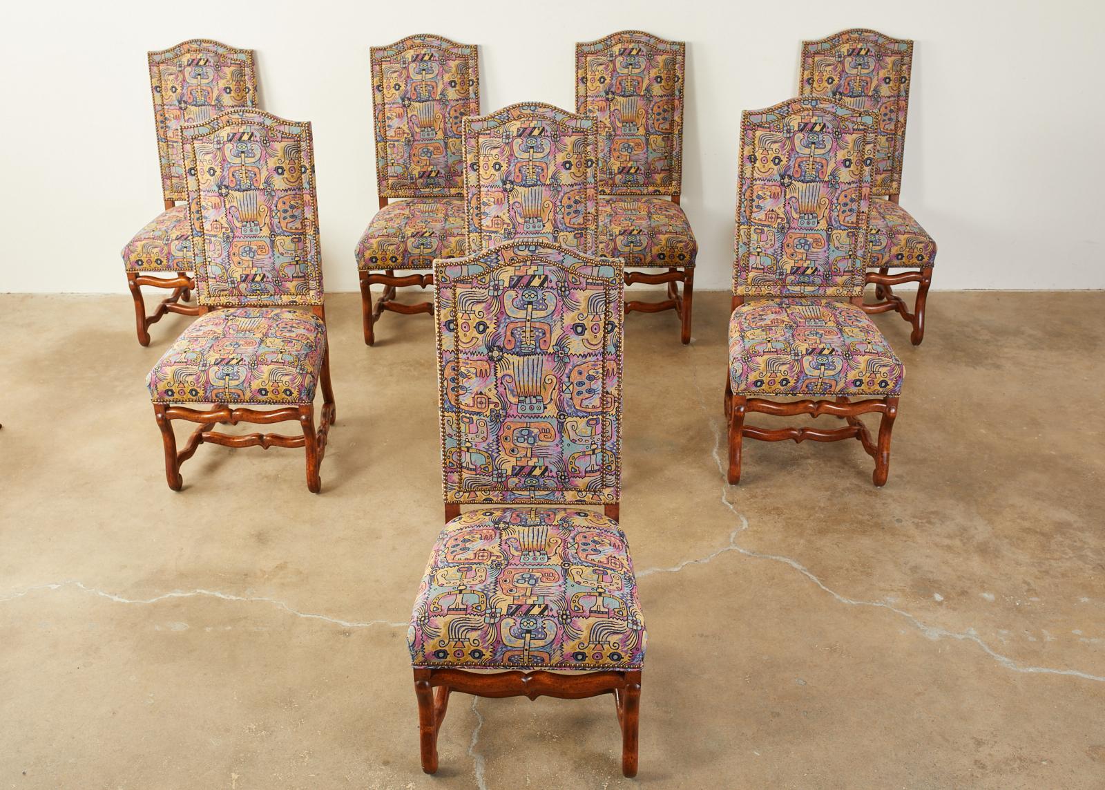 Stunning set of eight French dining chairs featuring a modern redux upholstery with a whimsical abstract expressionist figural artwork design. The chairs are made in the Louis XIV Os de Mouton taste crafted from rich walnut. The modernist fabric is