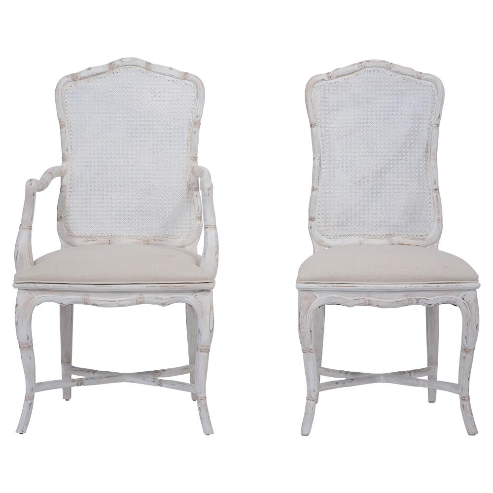 An extraordinary set of eight dining room chairs hand-crafted out of wood with its original caning that has been newly painted in an oyster color with a unique distressed finish. this set of eight features two armchairs & six side chairs with a faux