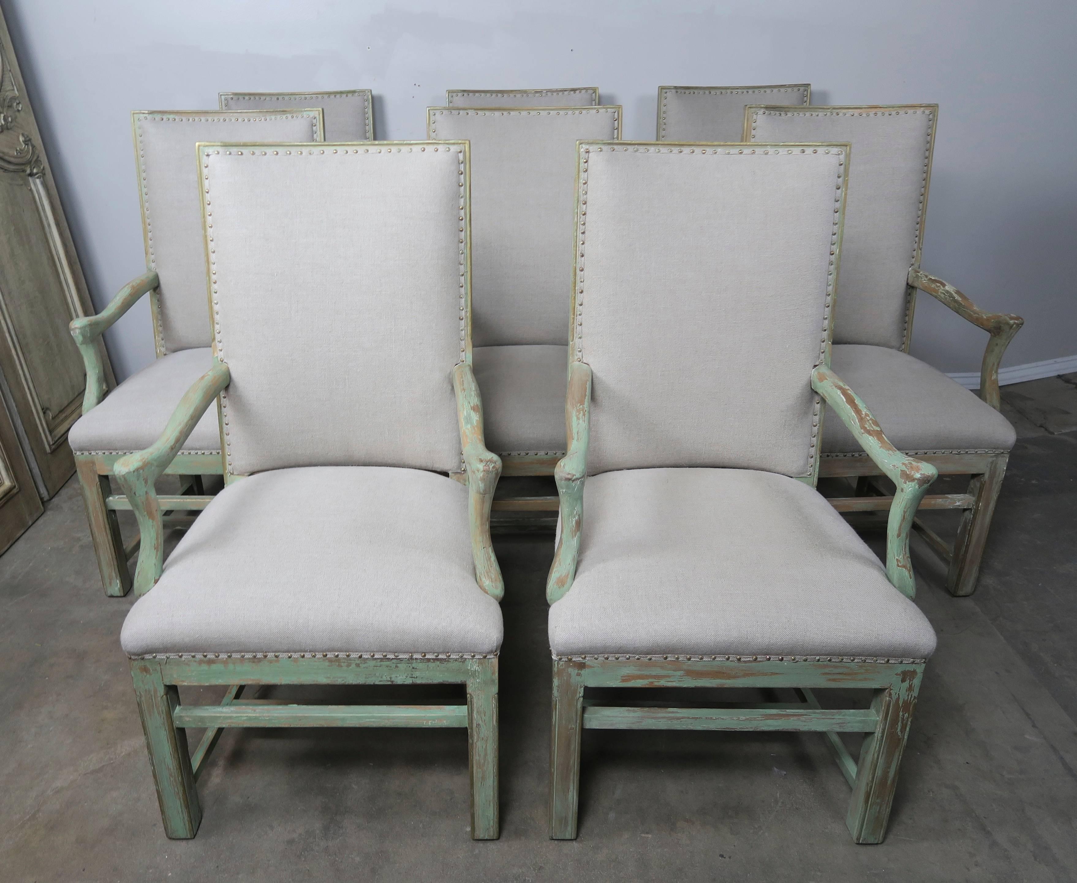 Set of eight soft green painted Swedish ladder back dining chairs newly upholstered in a 100% Pindler & Pindler linen with original spaced nailhead trim detail. Measures: 20