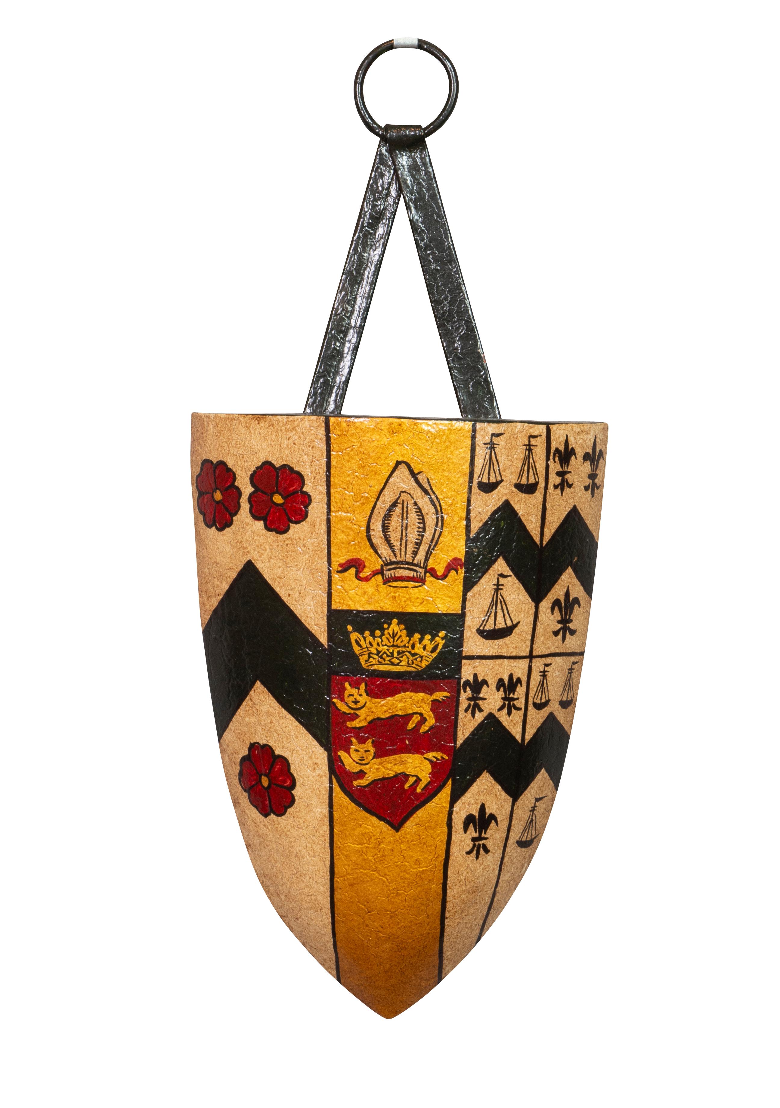 Each of shield shape with tole strap and ring featuring different coats of arms and family crests.