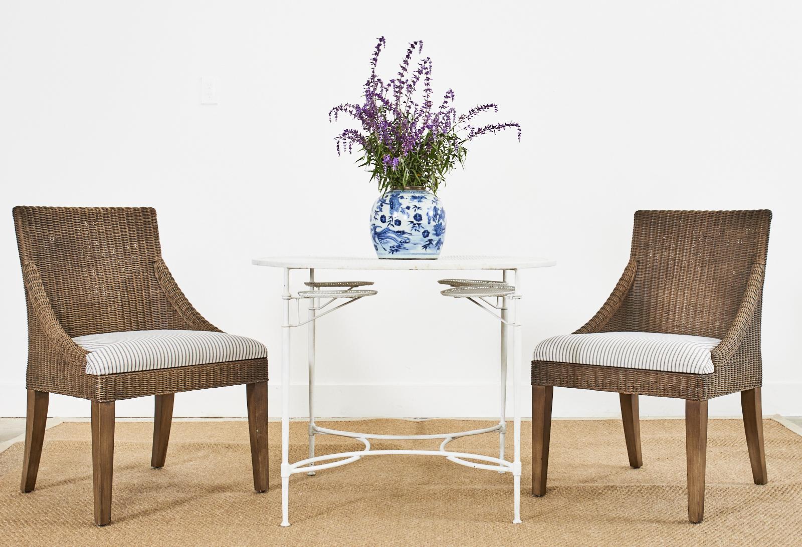 California organic modern coastal style set of eight dining chairs by Palecek. The chairs feature a hardwood frame covered with hand-woven natural rattan peel wicker. The chairs have gracefully curved sides that conjoin to a generous seat newly