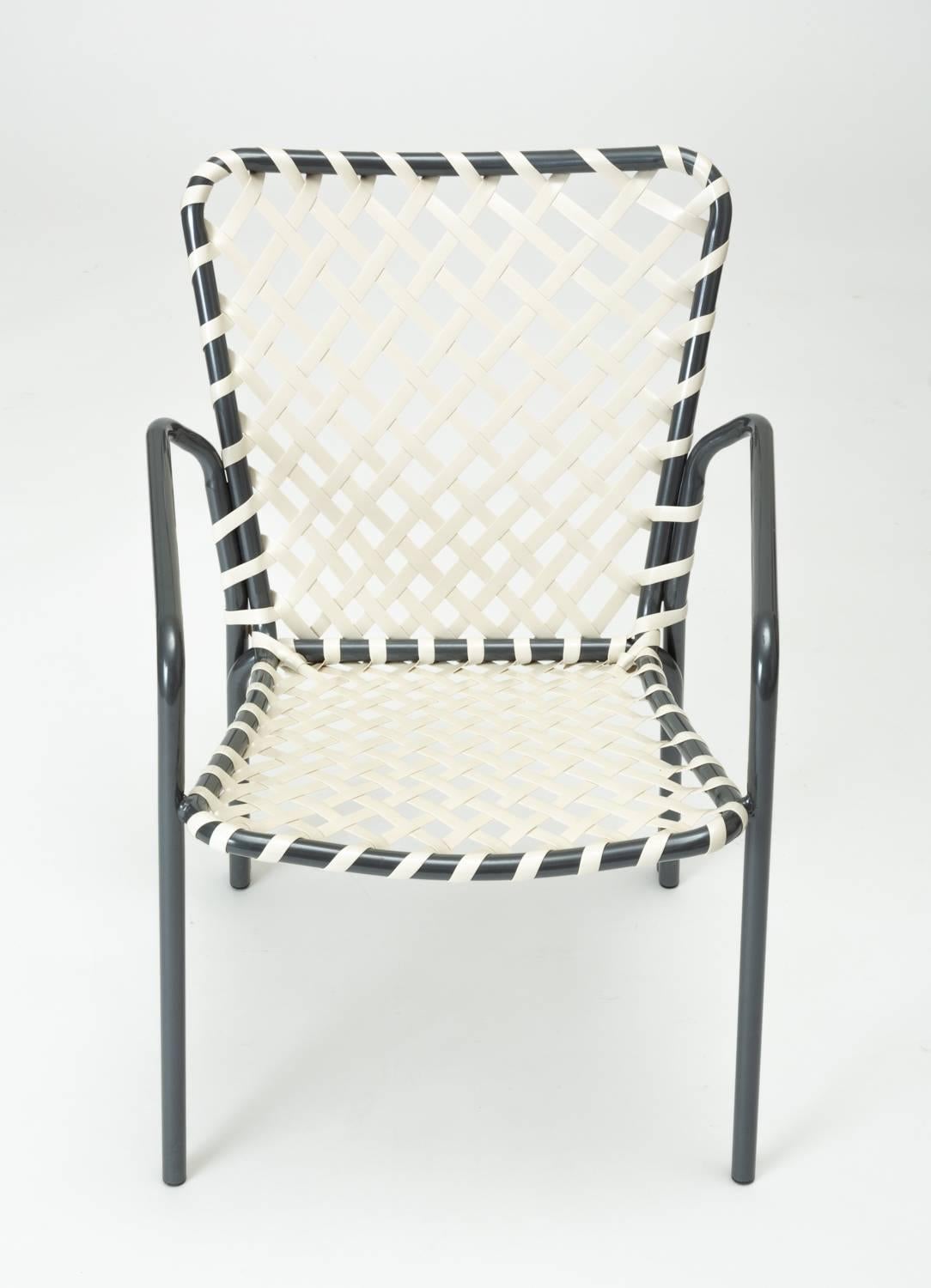 A set of eight patio dining chairs from the Ames Aire patio collection by the O. Ames Company of West Virginia. With a lightweight frame in aluminium, the chairs have a slight tulip back and curved arms. Tightly woven white vinyl lacing forms the