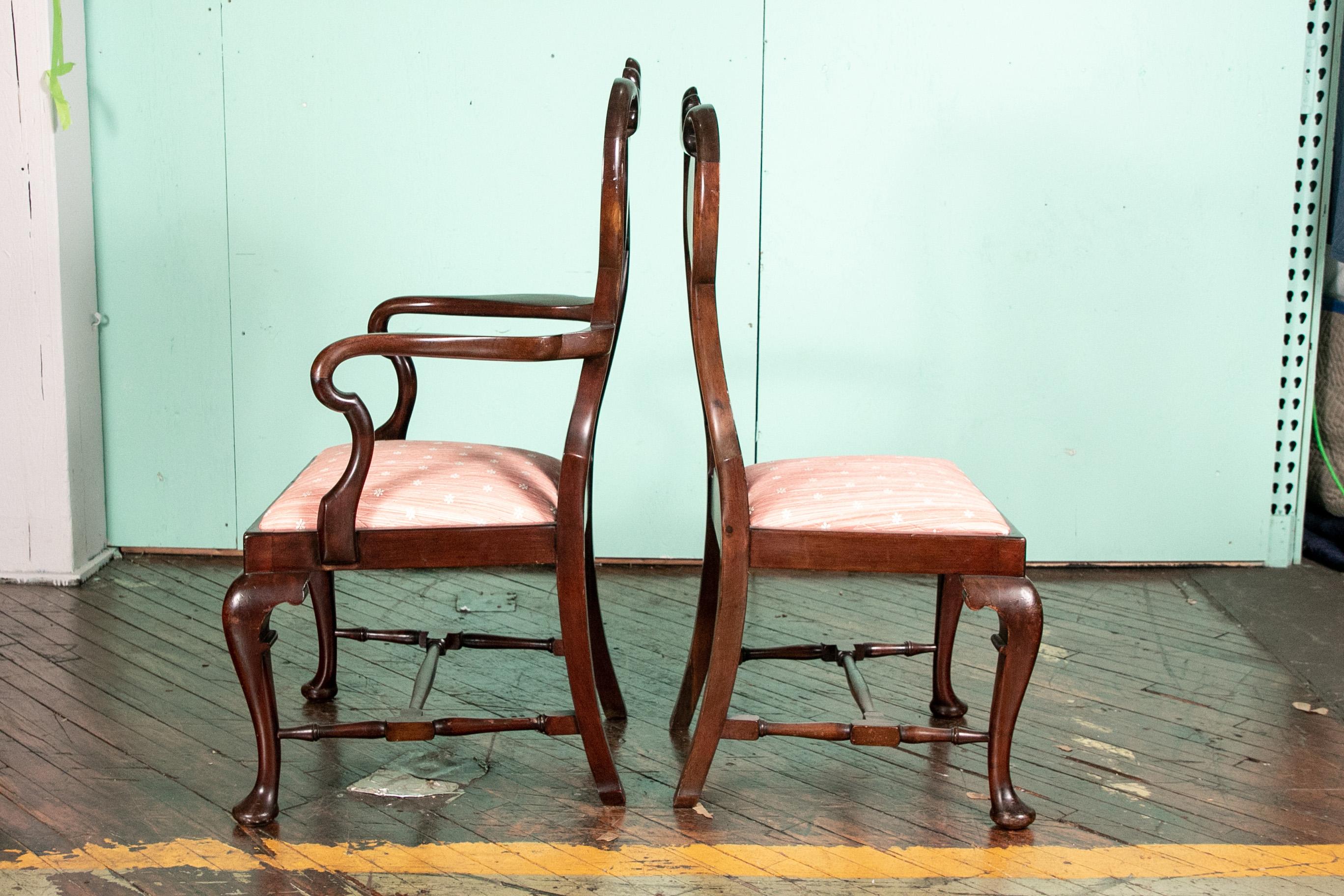 With very fine pronounced form and excellent proportions. Two arm and six side chairs. The splat backs with finely carved shells on the crests and shepherd's crook scrolled arms. Raised on cabriole legs in front with carved knees and pad feet,