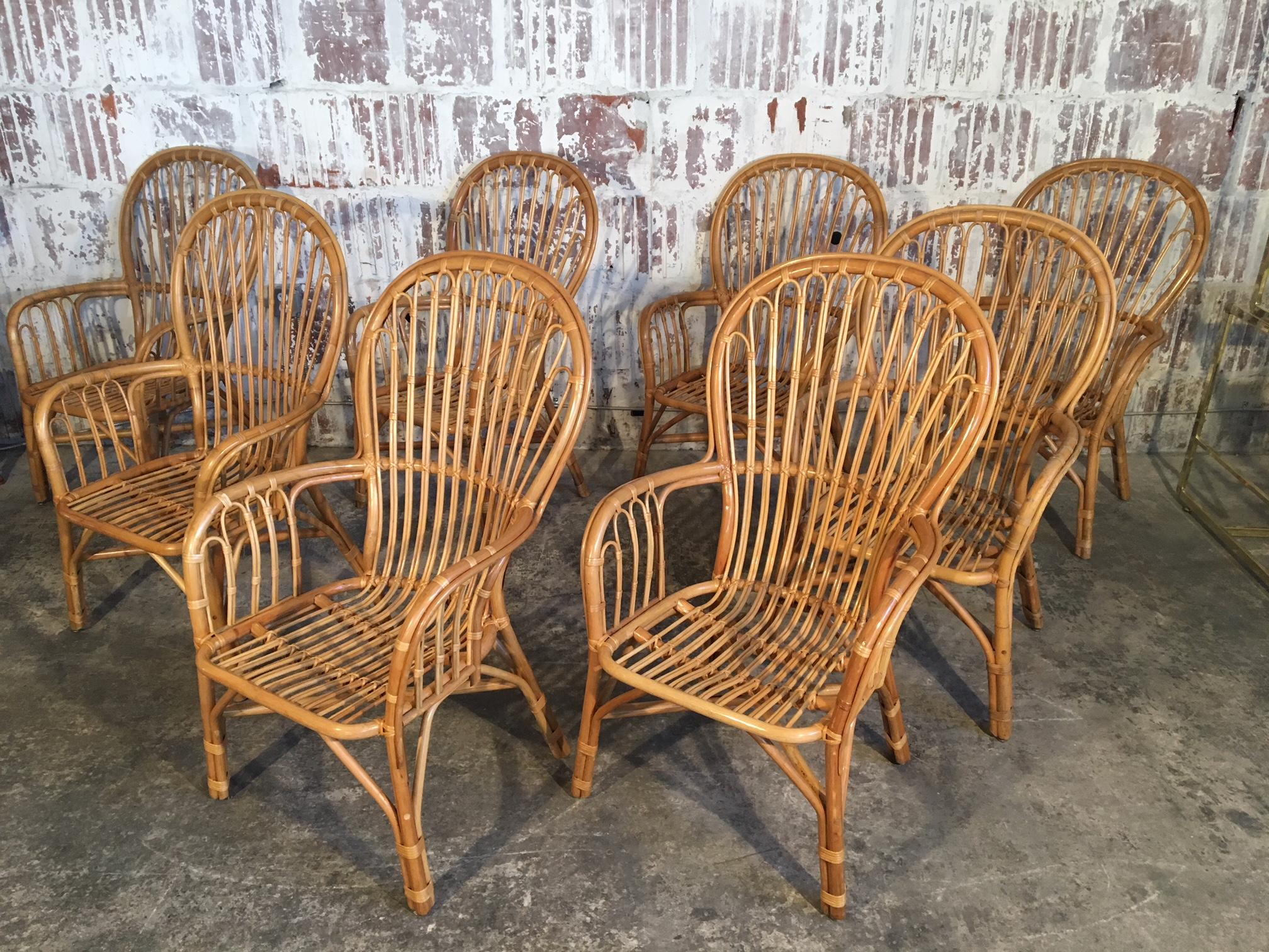 Set of 8 rattan fan-back arm chairs perfect for your tropical Palm Beach decor. Great example of midcentury bamboo furniture constructed by hand with craftsmanship that is no longer the norm. Some chairs are near perfect, others show abrasions