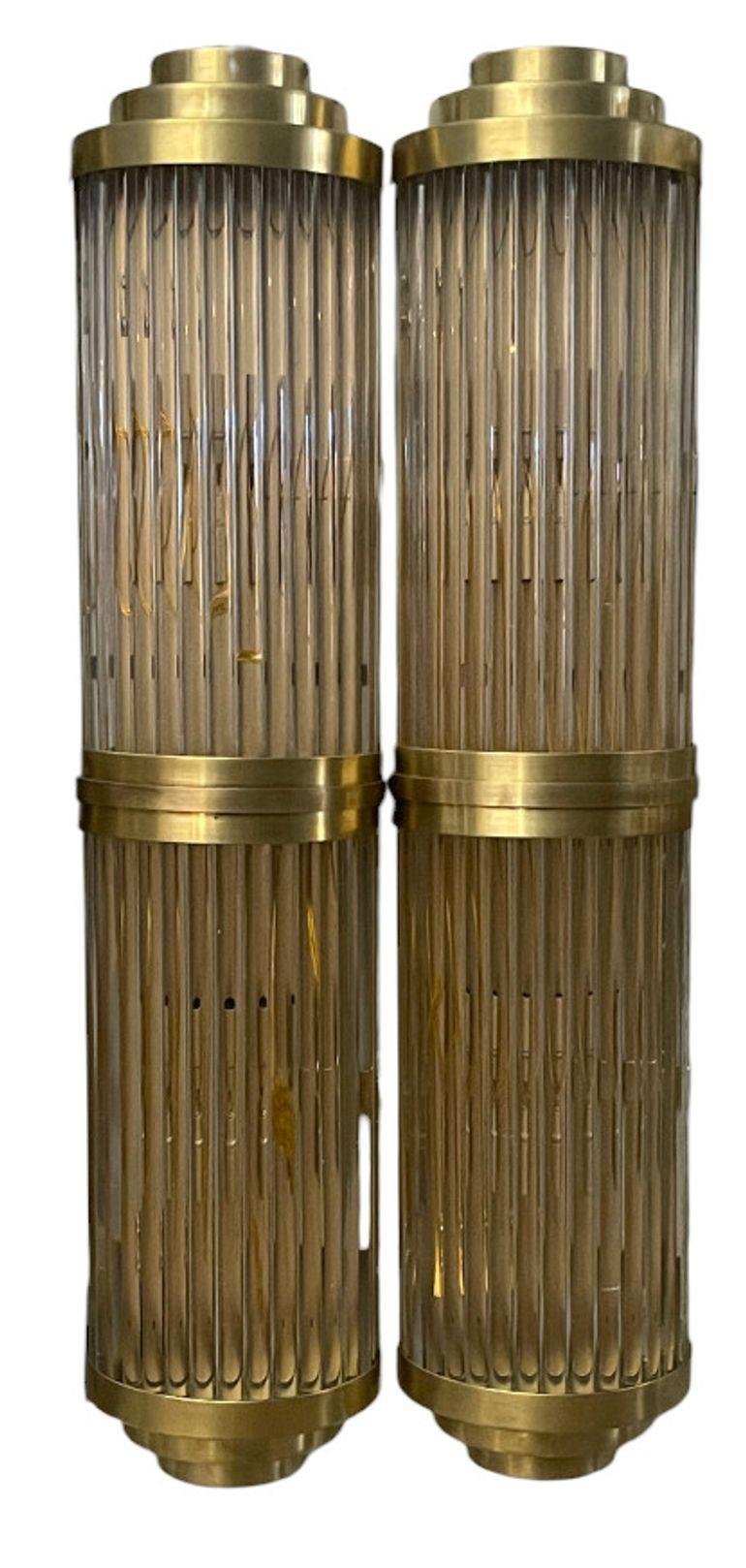 Grazioso set di otto applique italiane, ciascuna composta da tubi verticali in cristallo trasparente montati su telai in ottone lucido. Il design, noto come Romano Duo, riflette la raffinata eleganza dell'illuminazione italiana della fine del XX