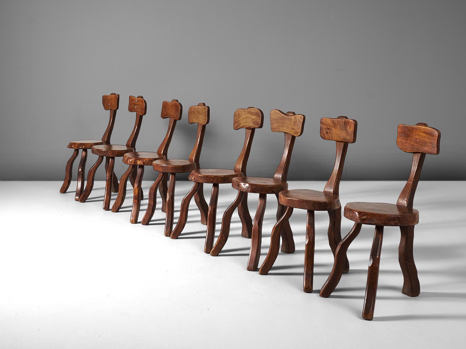 Set of eight root chairs, solid elmwood, France, 1970s. 

Eight slab chairs in elmwood, solid and stained dark brown. These chairs have a capricious appearance, due to the natural form and structure of the wood. 

Simplistic three-legged chairs,