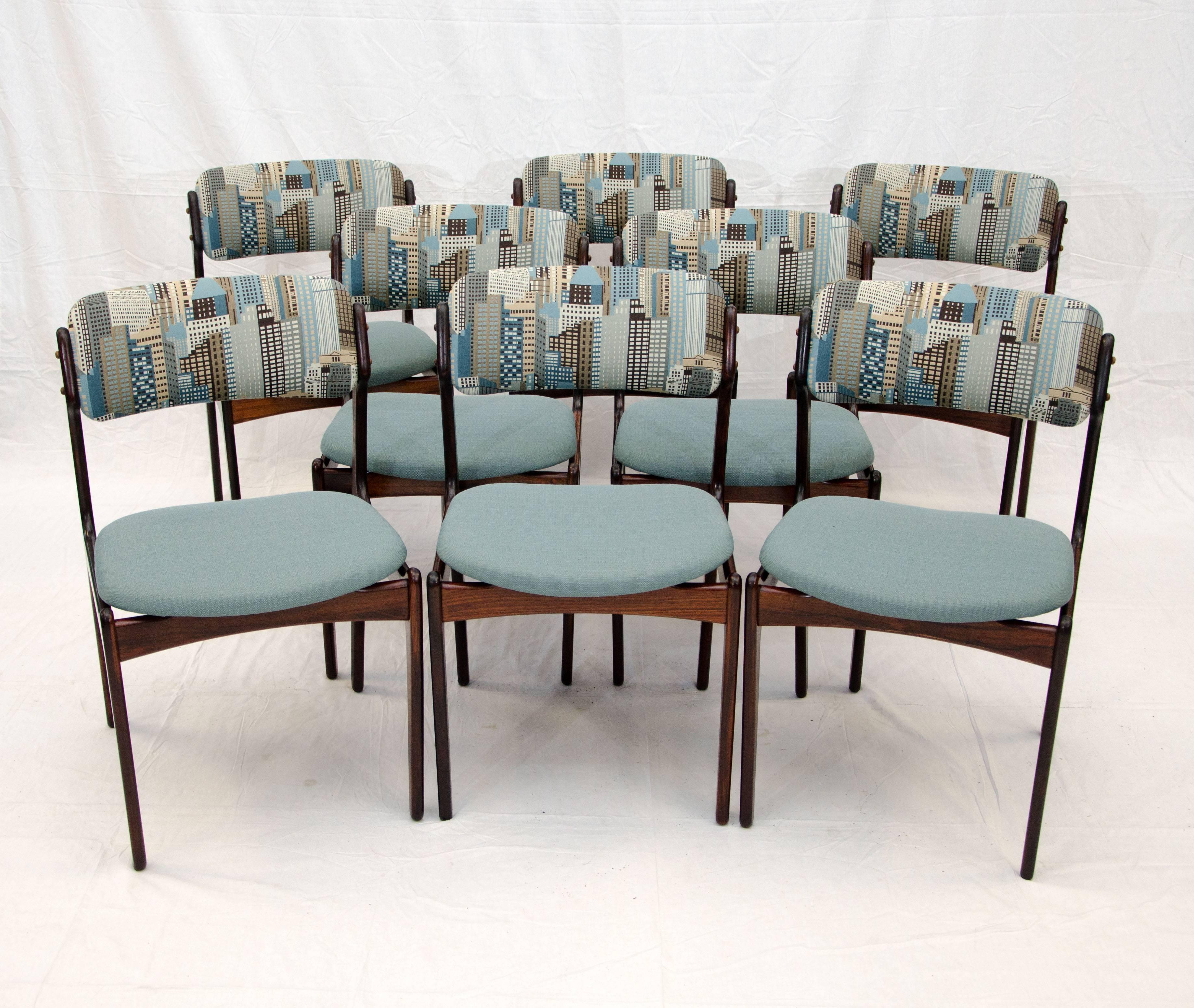 Beautiful set of eight rosewood Erik Buck dining chairs. These chairs are very comfortable with floating seats and curved upholstered backs. The back upholstery is a scene of high rise buildings, possibly inspired by New York City.