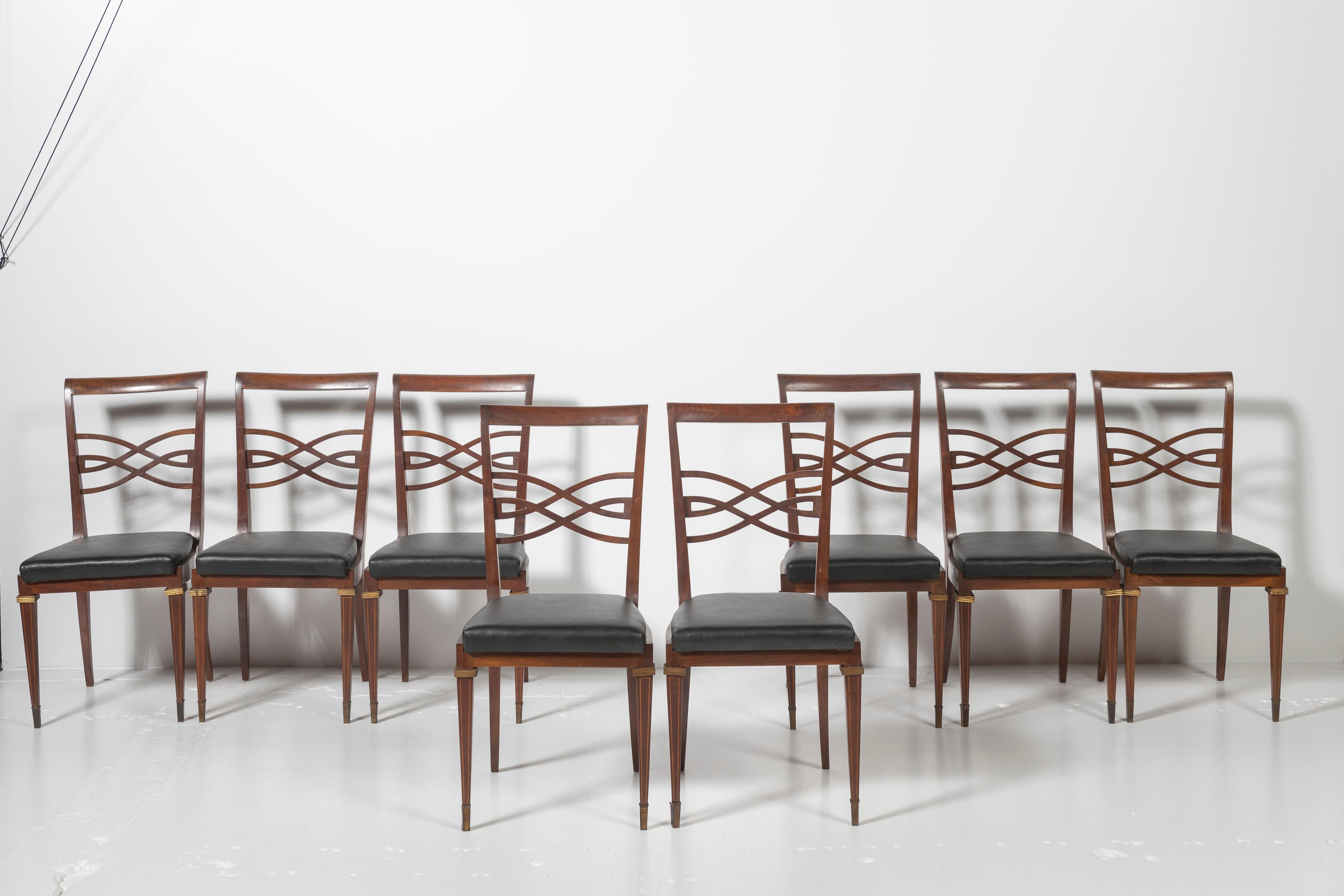 Attributed to Otto Sedie, these 8 Italian dining chairs are in rosewood with fretwork, brass details, and vinyl upholstery. Very graceful, mid century style, these chairs are a welcome addition to a room.