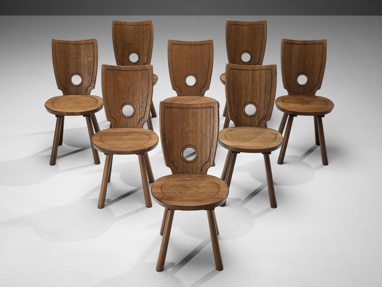 Set of eight dining chairs, stained oak, brass, metal, France, 1960s

Characteristic set of French dining chairs. In absence of decoration the rounded gap in the backrest gets an important visual role as it contrasts with the sharp, angular lines
