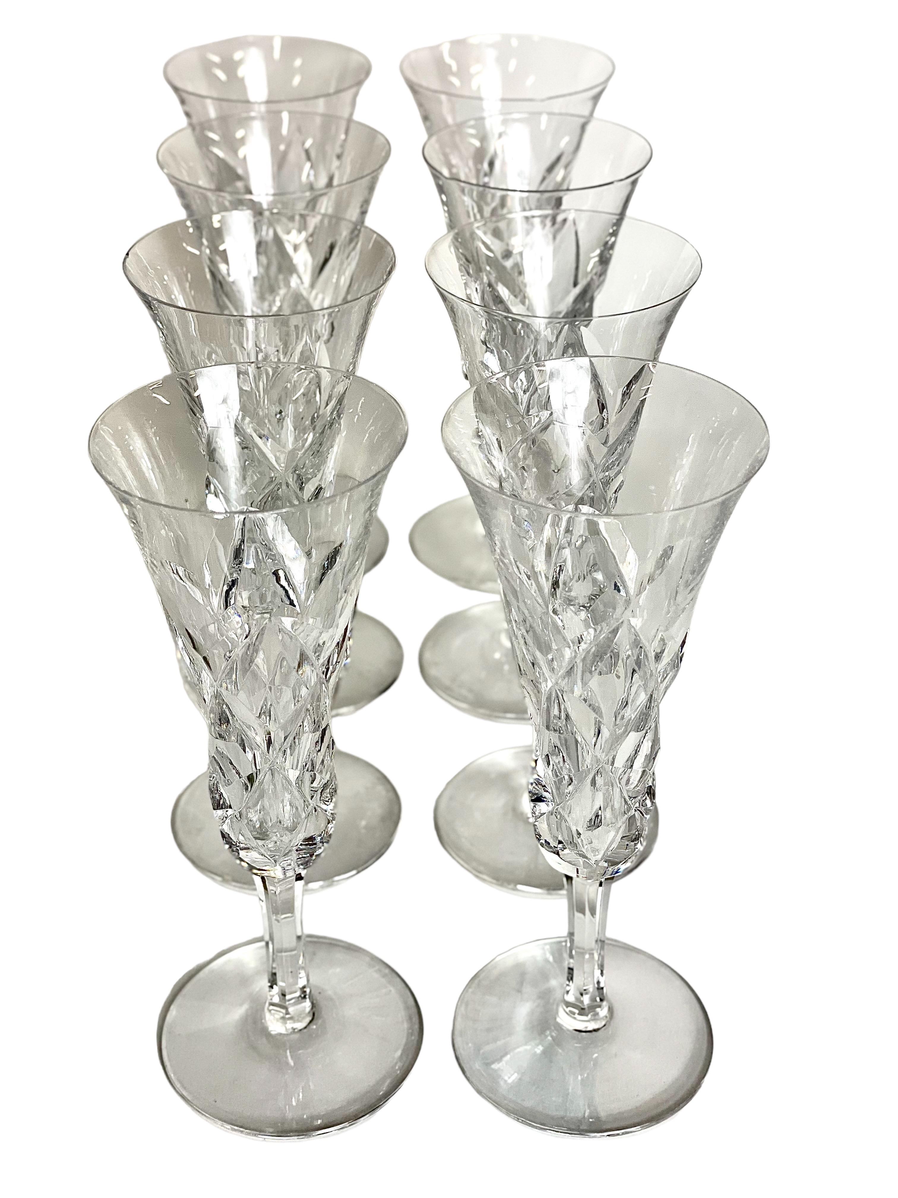 A glittering set of eight fine Saint Louis crystal Champagne flutes, from the 'Adour' pattern series. Dating from around 1950, these timeless glasses feature the classic Adour 'cross cut diamond' design on their body, with faceted stems and