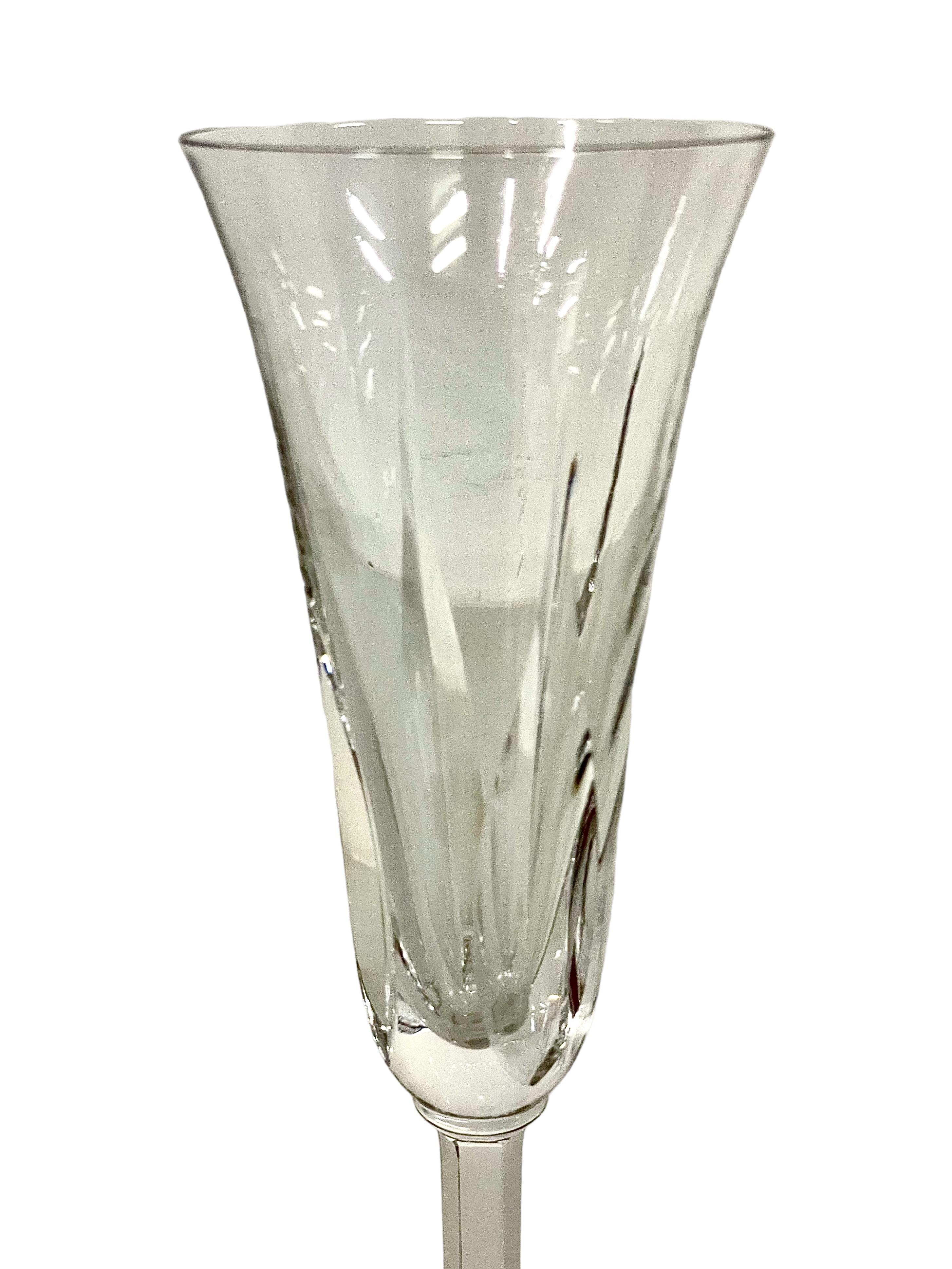 An exceptional set of eight crystal Champagne flutes in sparkling Saint-Louis crystal. The tulip- shaped chalice of each is cut with tall and pointed lozenges, while the stem features elegantly cut flat ribs. The glasses are all stamped