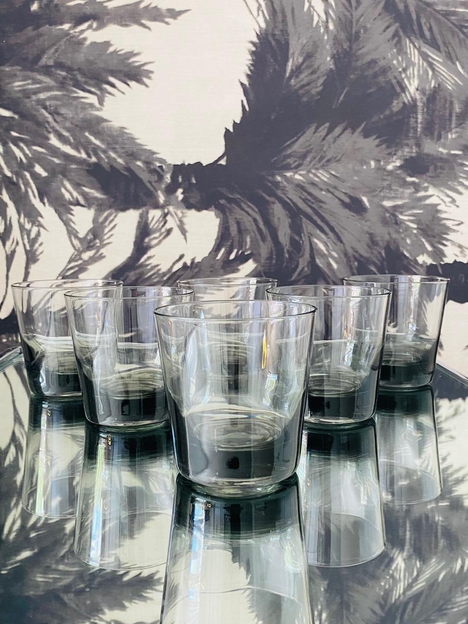 Set of eight vintage whiskey rock glasses with streamline design. The barware glasses are handblown with slightly tapered forms in translucent smoked grey glass. Makes a handsome addition to any barware or dinnerware collection.