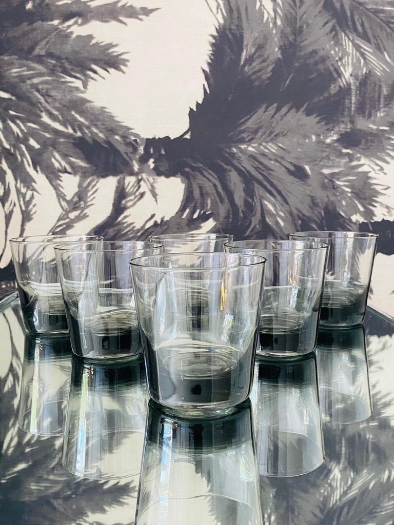 Vintage 1960's whiskey rock glasses with streamline design. The barware glasses are handblown with slightly tapered forms in translucent smoked grey glass. This Mid-Century Modern set makes a handsome addition to any barware or dinnerware collection.