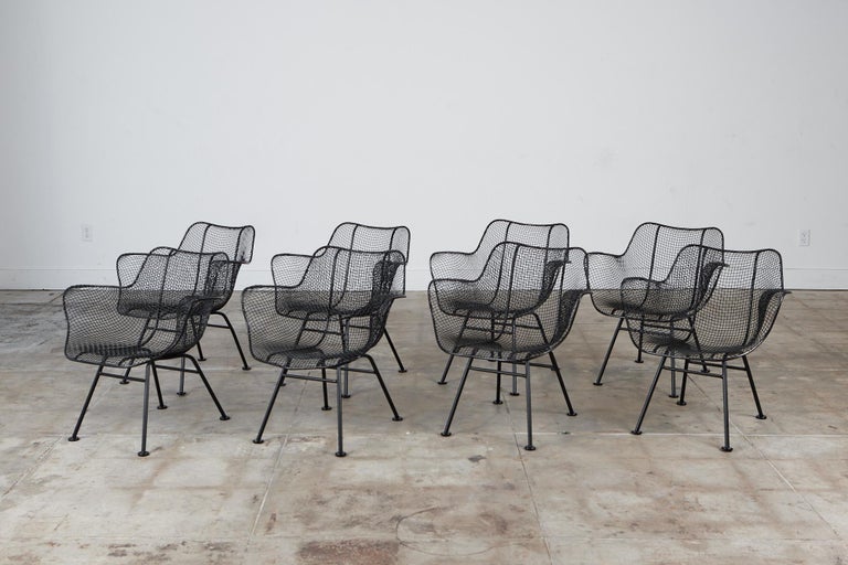 Set of eight armchairs by Russell Woodard for Woodard Furniture, c.1950s. The armchairs are from Russell Woodard’s “Sculptura” line designed in 1956. Each chair has a molded mesh frame that sits atop four wrought iron legs with disc feet. The chairs