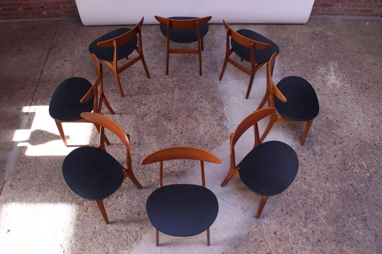 Set of eight dining chairs by renowned Danish architect, Vilhelm Wohlert, for Søborg (model #420). Composed of deeply sculpted solid teak frames with curved backrests and wide, floating seats supported by triangular posts. The legs are connected to