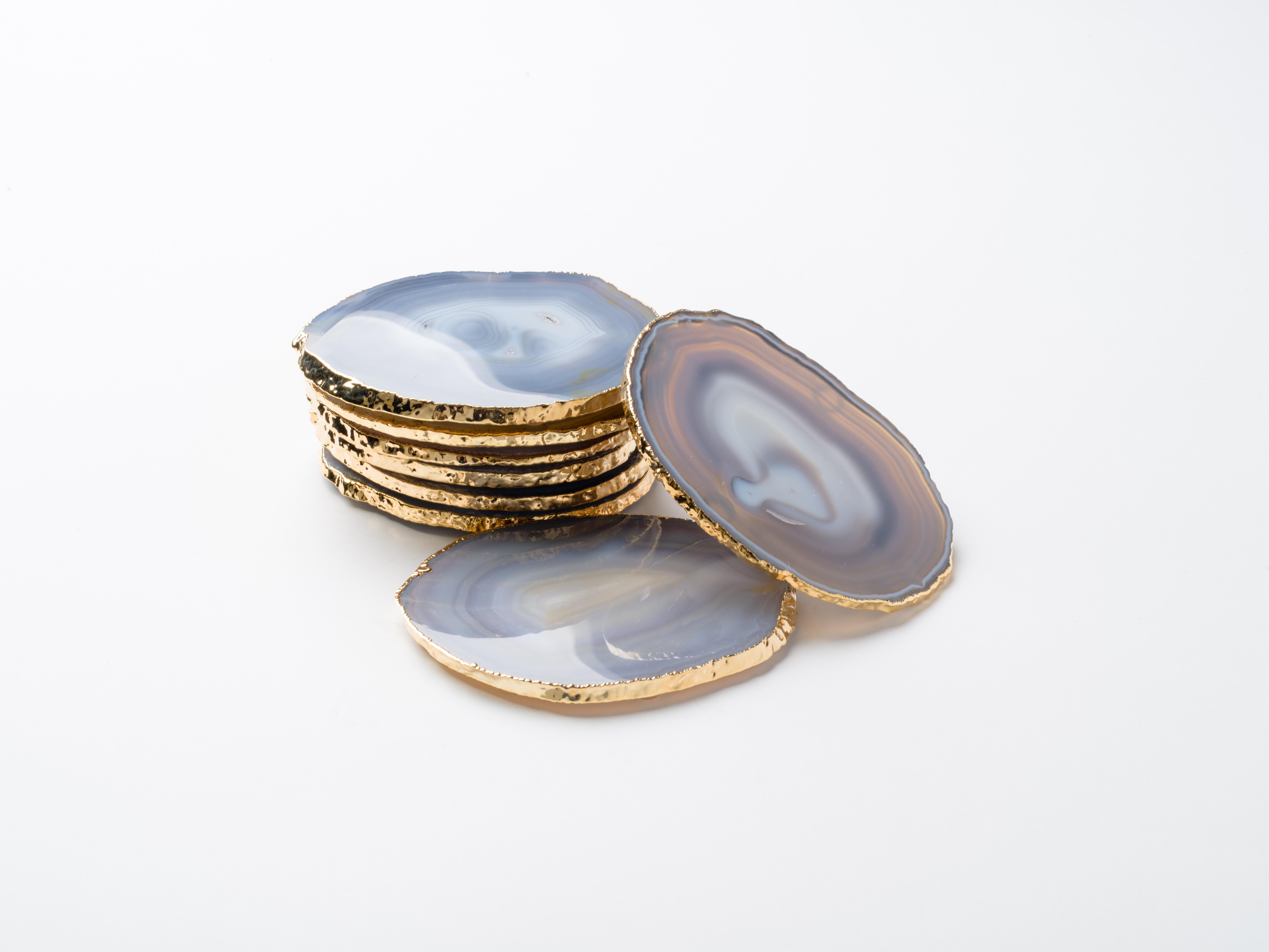 Stunning natural agate and crystal coasters with 24-karat gold plated edges. Three color variations are available: Teal, onyx or grey. Polished fronts and natural rough edges. No two pieces are alike. Make beautiful accessories to any coffee table