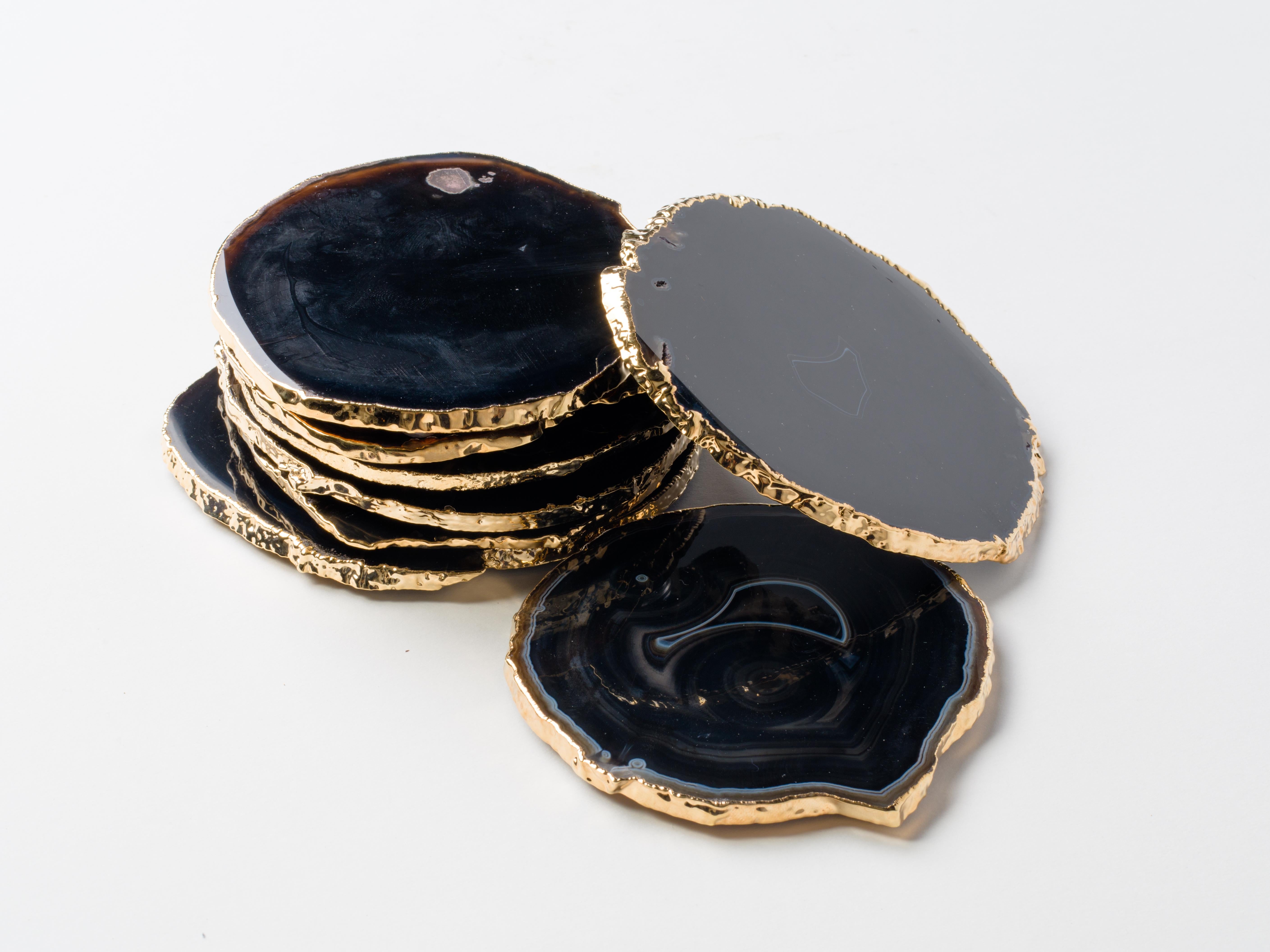 Organic modern agate and crystal coasters in black onyx and brown with 24-karat gold-plated edges. The set features polished fronts and natural rough edges. No two pieces are alike. Stunning natural accessories are a welcomed addition to any coffee