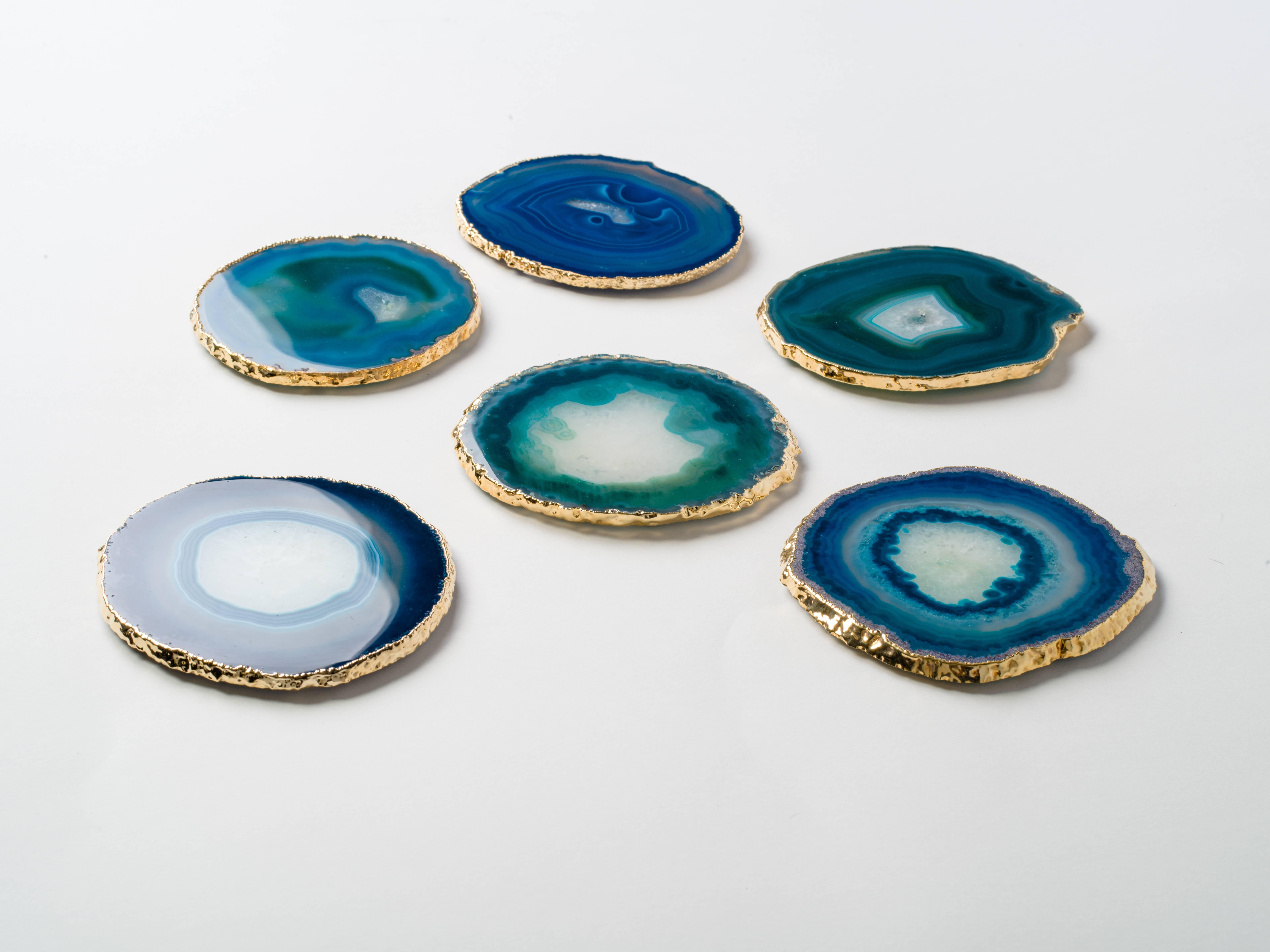 Stunning natural agate and crystal coasters with 24-karat gold plated edges. Polished fronts and natural rough edges. No two pieces are alike. Make beautiful accessories to any coffee table or dining table setting. Three color variations are