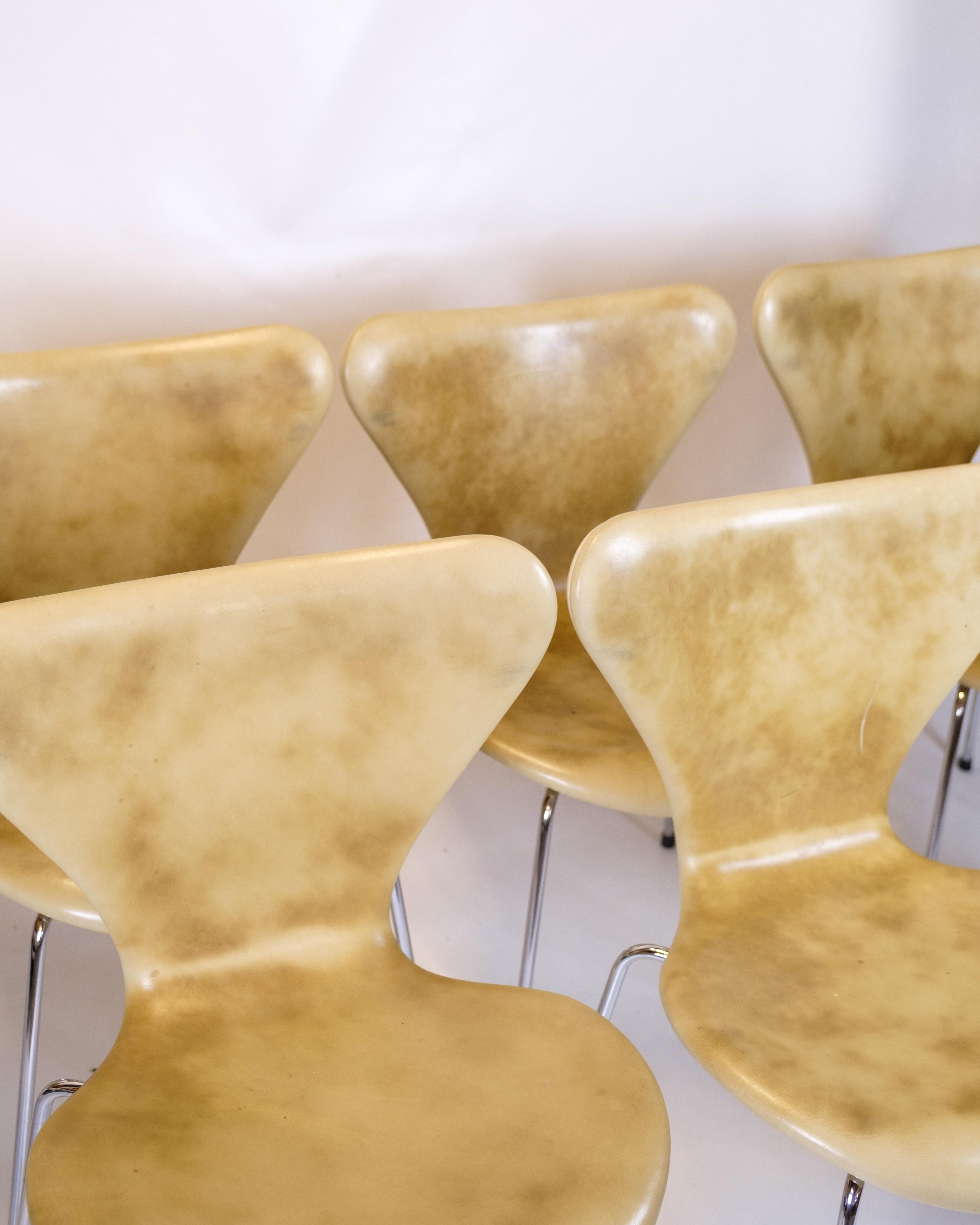Set of eight Syver chairs, model 3107, designed by Arne Jacobsen in 1955 and produced by Fritz Hansen. The chairs are upholstered in beautifully patinated natural-colored leather, which gives each chair its own unique expression. The frame is made