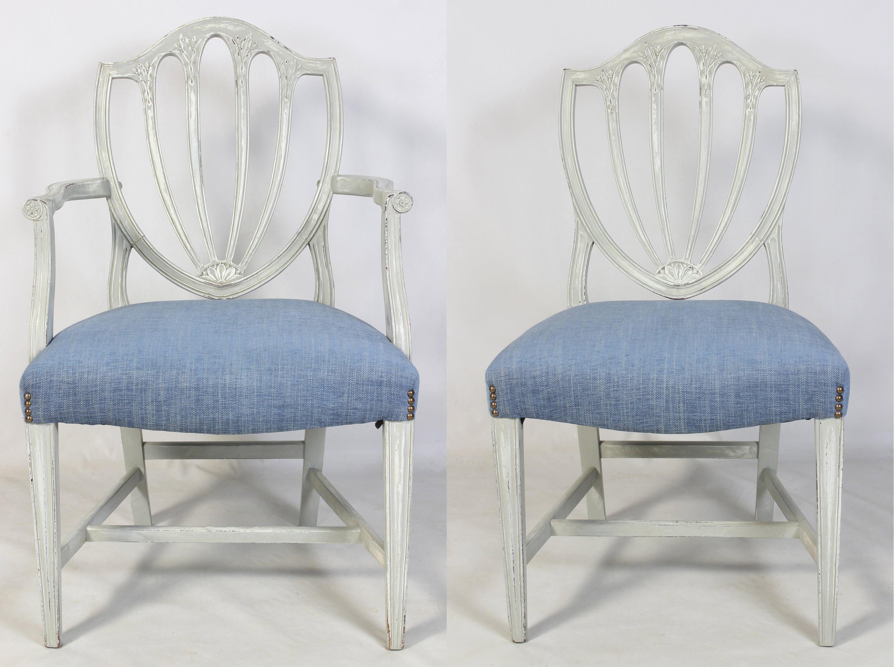 A set of eight solid mahogany Hepplewhite style shield back dining chairs comprising two arms and six sides beautifully painted in a soft French gray and newly upholstered in medium blue cotton/linen fabric accented with nail heads.