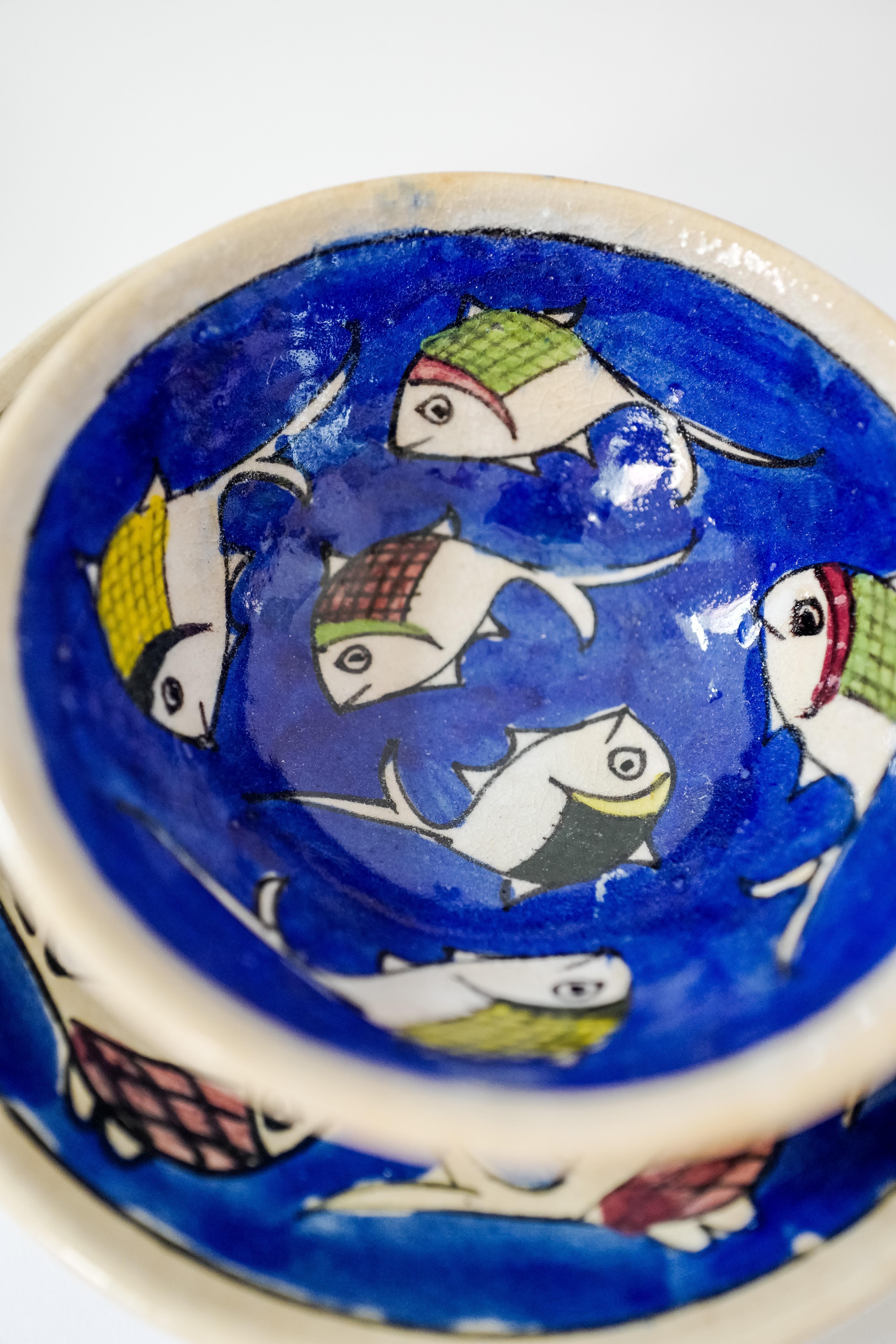 Ein schöner Satz von acht italienischen Keramikgeschirrteilen, die von Hand blau mit Fischmotiven bemalt sind. Das Set enthält vier Essteller und vier Schalen aus Sizilien, Italien. Neu hergestellt und handgefertigt in einer antiken Technik, so dass
