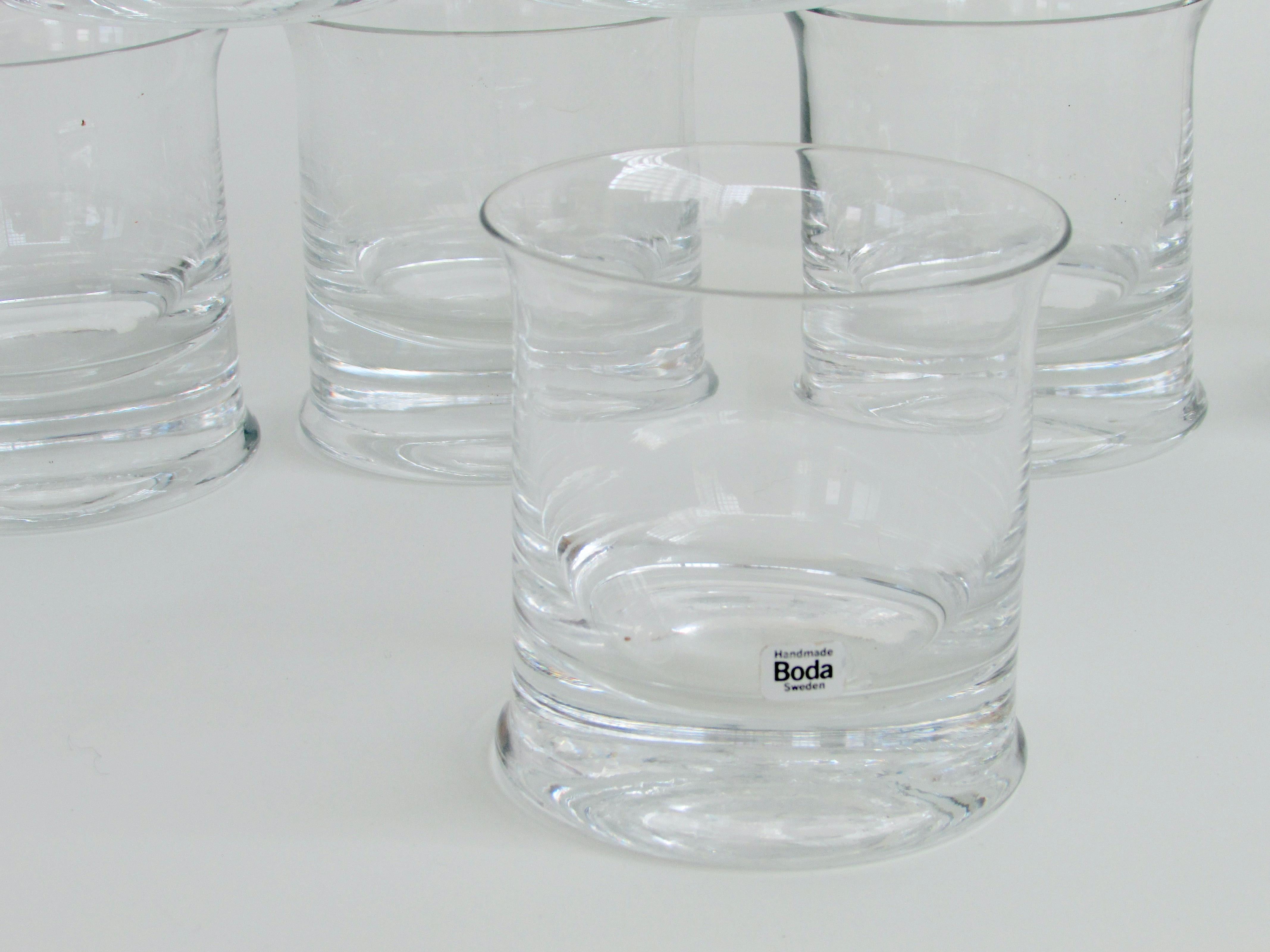 Eight whiskey or rocks glasses designed by Signe Person Melin   ( 1925 - 2022 ) . Produced by Kosta Boda Sweden in the early 1970's . Thick glass base with flared opening . The set is in fine condition with several Kosta Boca Hand Made paper labels