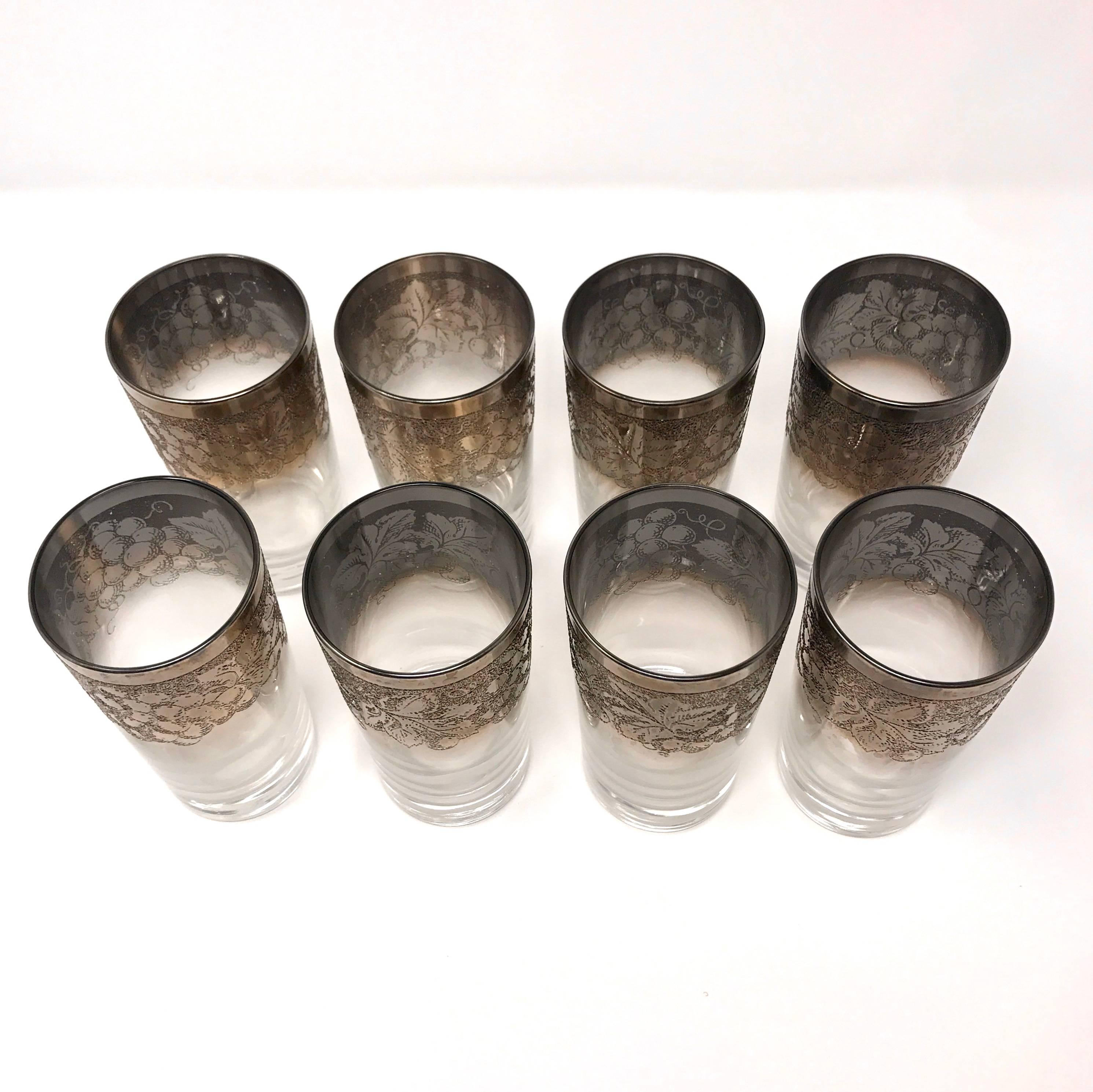 Set of eight midcentury highball glasses by Dorothy Thorpe. The crystal glasses feature a sterling silver overlay, with a design of grape vines, leaves, and clusters. Price is for the set.