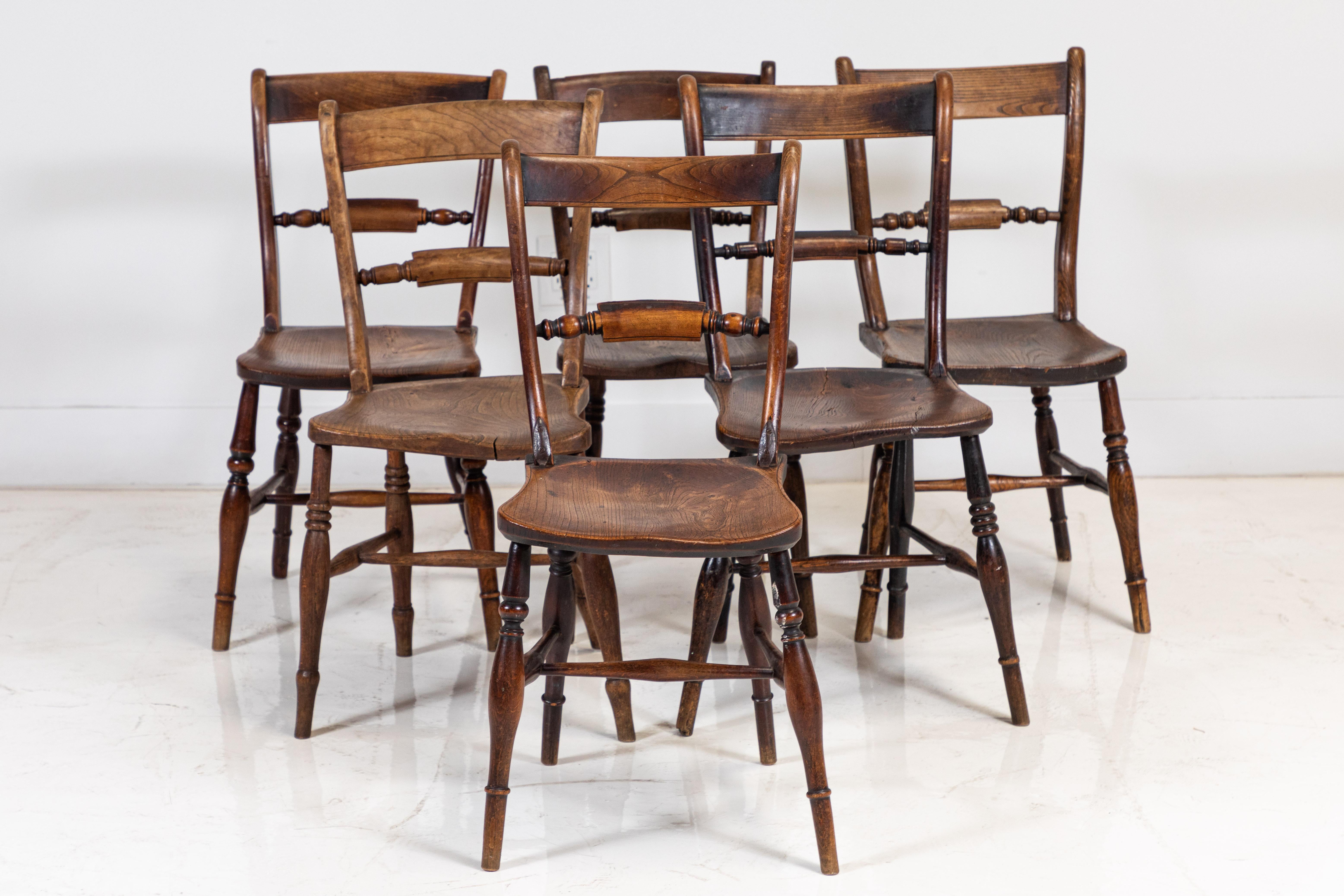 Set of eight wooden Spanish dining chairs, six side chairs and two armchairs. The chairs are petite in size and the wood has beautiful colorations from age. The arm chairs measure: 16