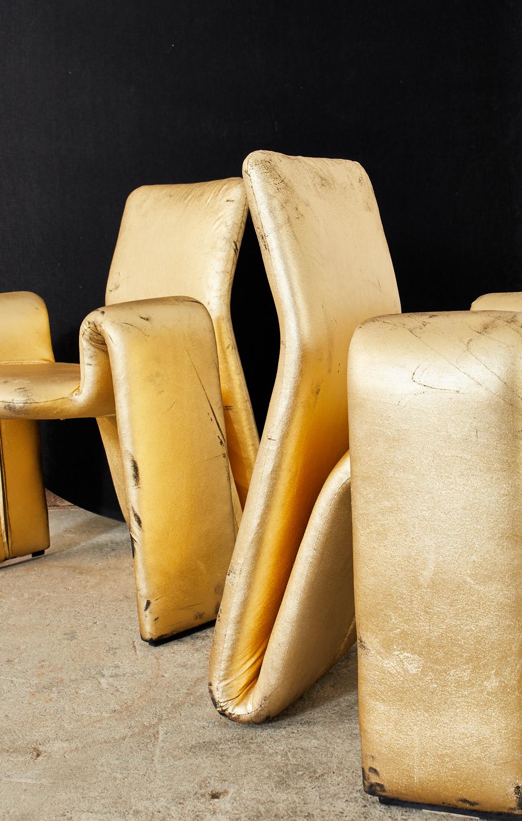 Rare set of eight dramatic metallic gold dining chairs designed by Steve Leonard for Brayton. The chairs feature a post modern design crafted from a metal frame covered with foam. The sculptured form is not only unique they are the most comfortable